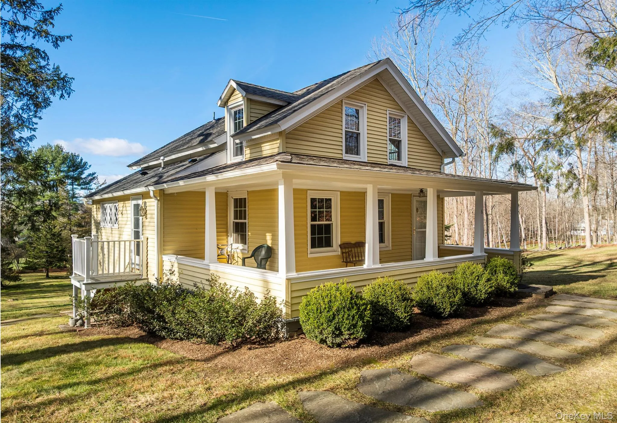 View of property exterior with a porch, a yard, and a shingled roof View of property exterior with a porch, a yard, and a shingled roof