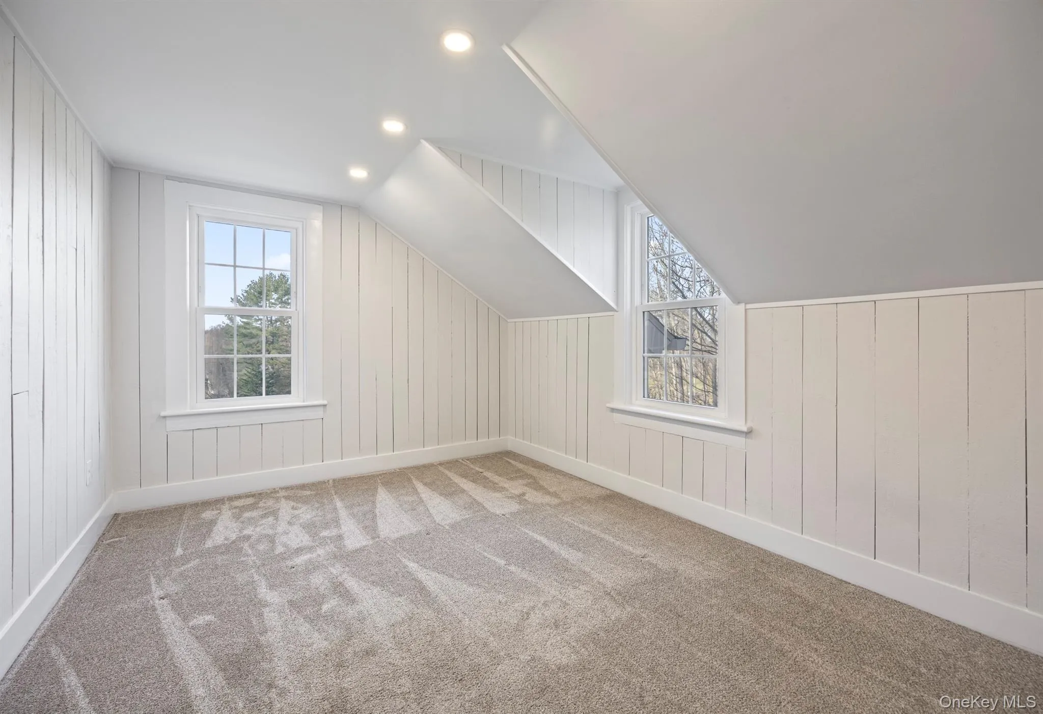 Bedroom #1 with carpet floors, plenty of natural light, recessed lighting, and wooden walls Bedroom #1 with carpet floors, plenty of natural light, recessed lighting, and wooden walls