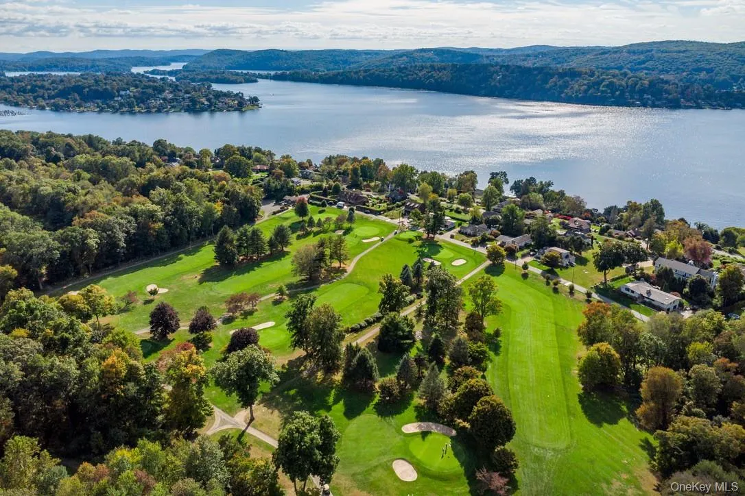Bird's eye view of a golf course and a nearby body of water Bird's eye view of a golf course and a nearby body of water