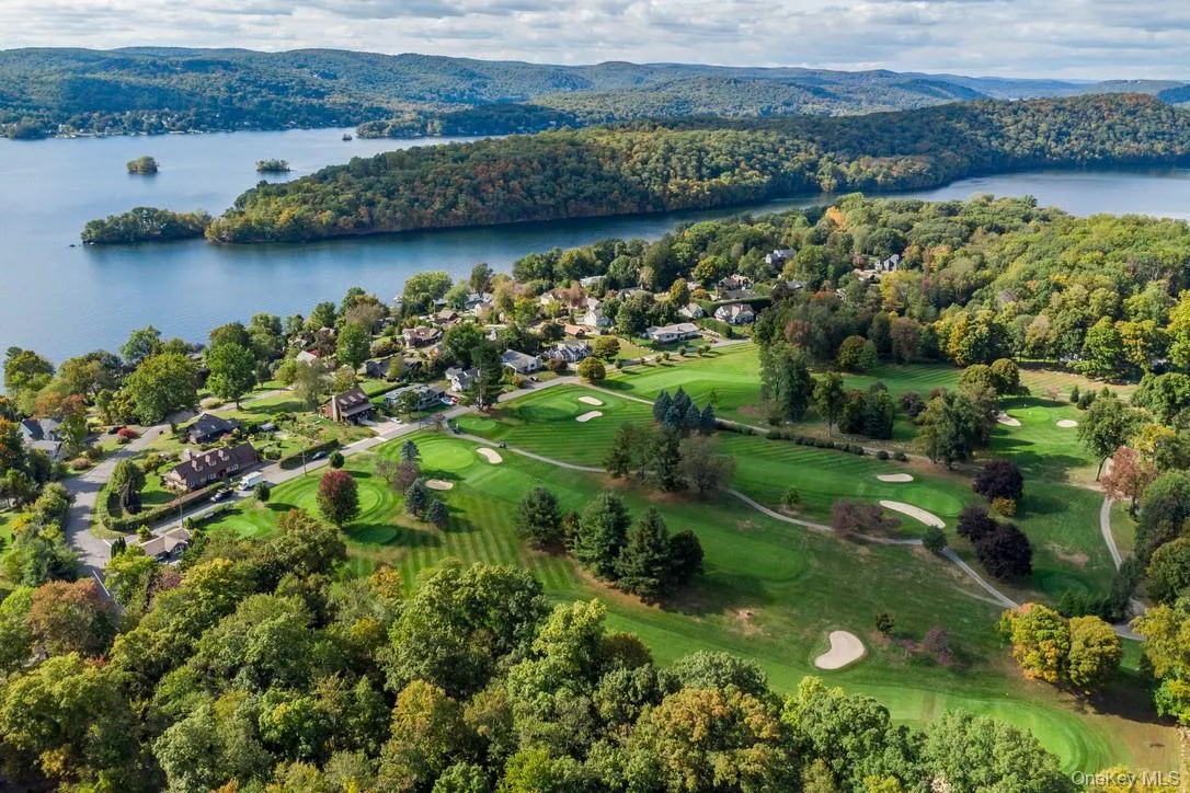 Aerial perspective of suburban area featuring a nearby body of water and a golf club Aerial perspective of suburban area featuring a nearby body of water and a golf club