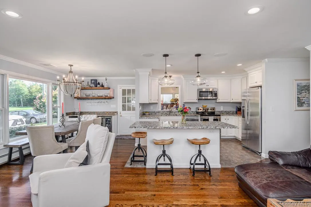 Kitchen featuring crown molding, recessed lighting, pendant lighting, white cabinetry, and appliances with stainless steel finishes Kitchen featuring crown molding, recessed lighting, pendant lighting, white cabinetry, and appliances with stainless steel finishes
