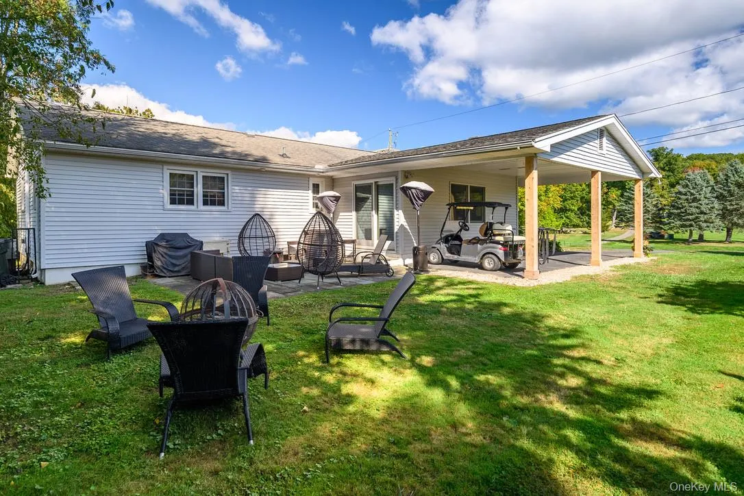 Back of property with an outdoor fire pit, a yard, and a patio area Back of property with an outdoor fire pit, a yard, and a patio area