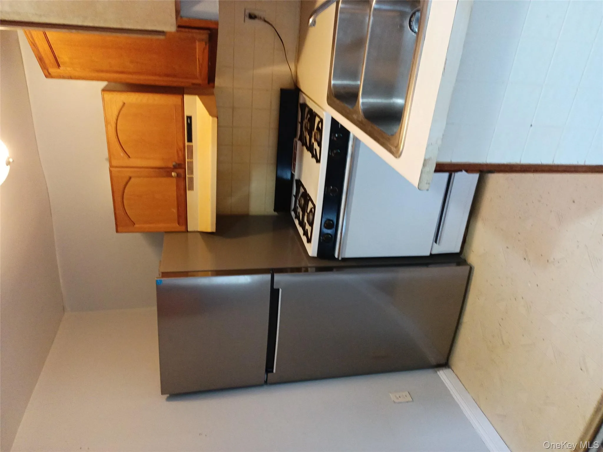 Kitchen with appliances with stainless steel finishes, backsplash, light countertops, ventilation hood, and light floors Kitchen with appliances with stainless steel finishes, backsplash, light countertops, ventilation hood, and light floors