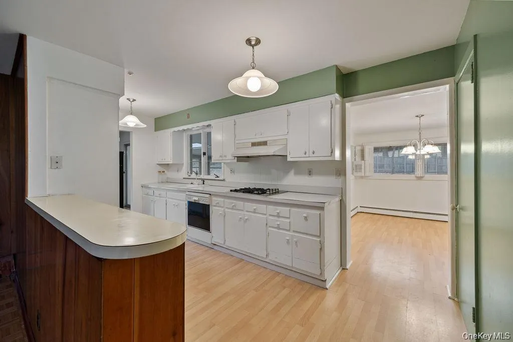 Kitchen with pendant lighting, white cabinets, and light countertops Kitchen with pendant lighting, white cabinets, and light countertops