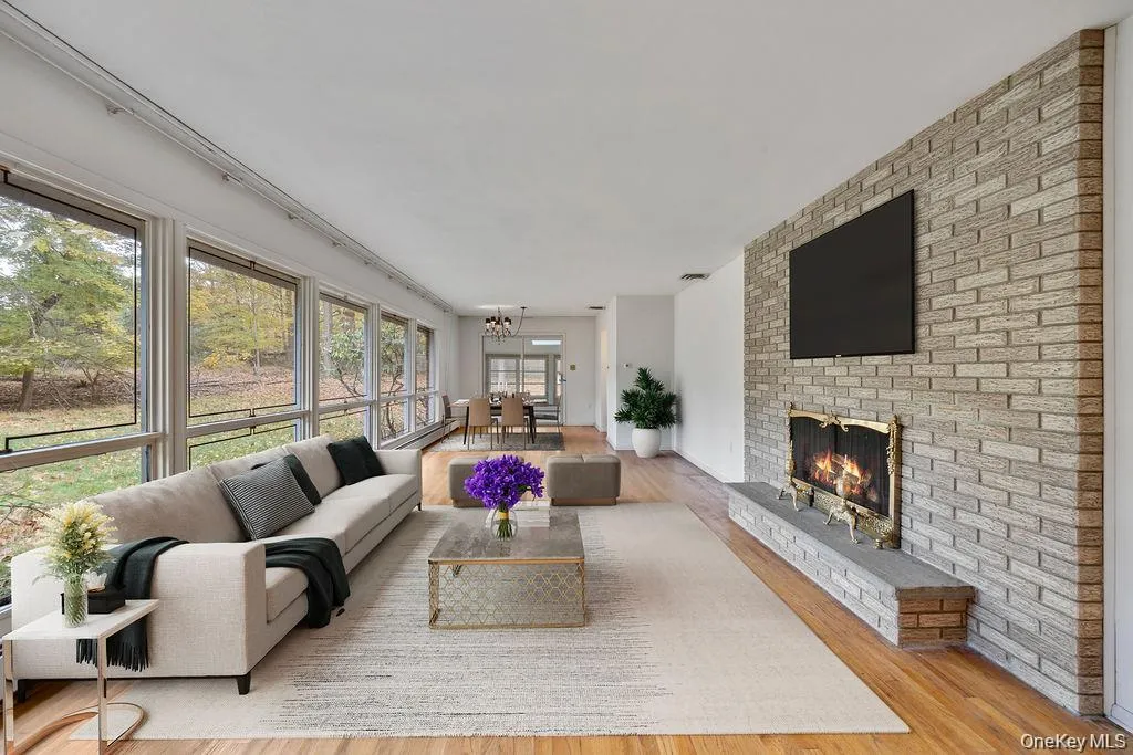 Living area with wood finished floors, a fireplace, and a chandelier Living area with wood finished floors, a fireplace, and a chandelier