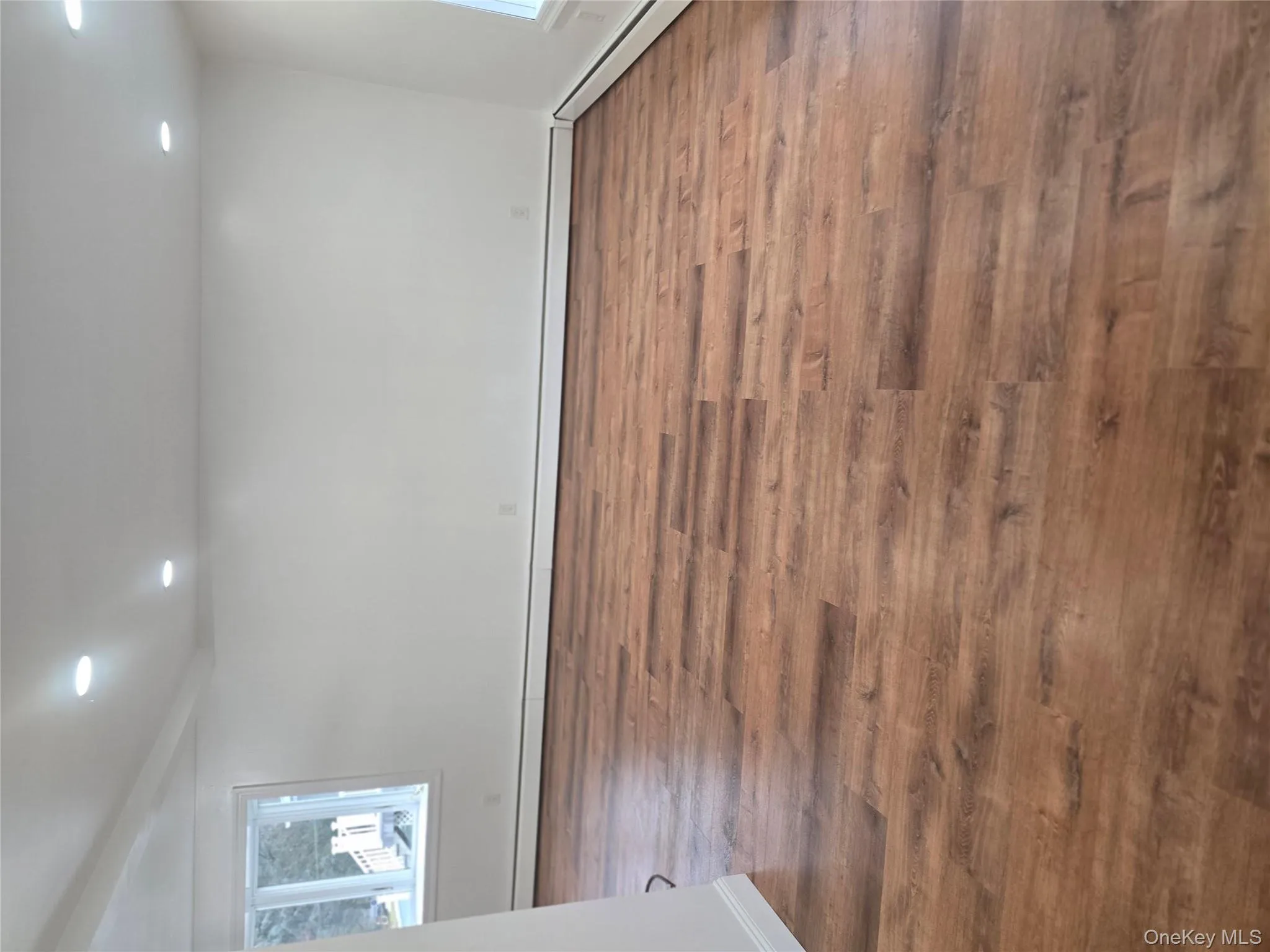 Spare room with baseboard heating, recessed lighting, and dark wood-style flooring Spare room with baseboard heating, recessed lighting, and dark wood-style flooring