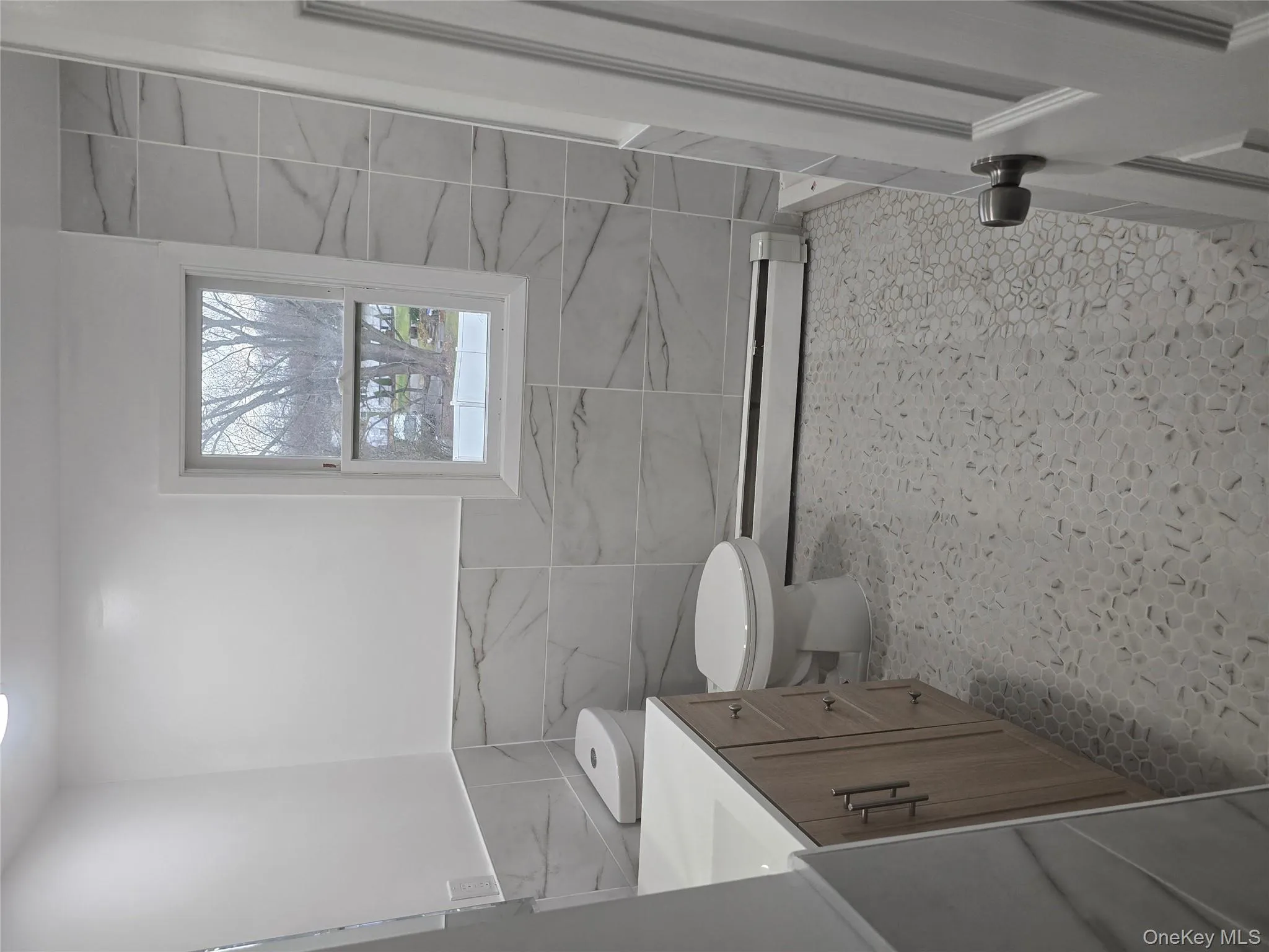 Bathroom with vanity, tile walls, wainscoting, and baseboard heating Bathroom with vanity, tile walls, wainscoting, and baseboard heating