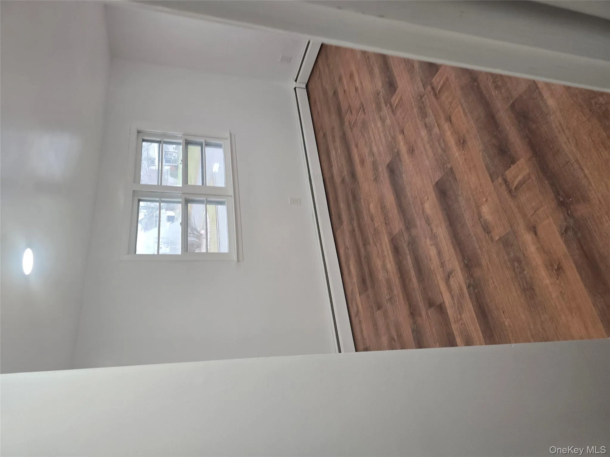 Spare room featuring dark wood-style flooring, a baseboard heating unit, and recessed lighting Spare room featuring dark wood-style flooring, a baseboard heating unit, and recessed lighting