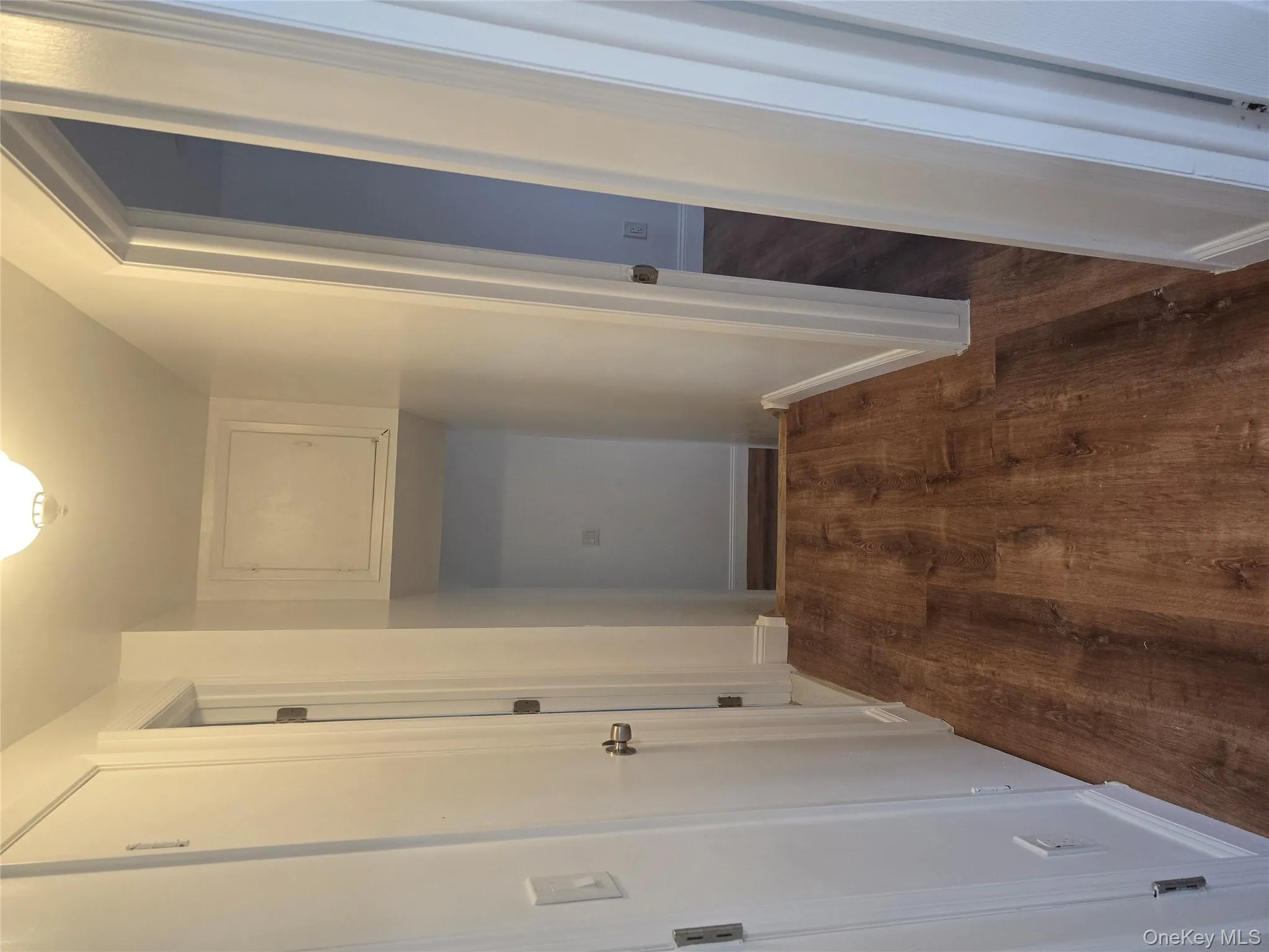 Hallway with dark wood finished floors and baseboards Hallway with dark wood finished floors and baseboards