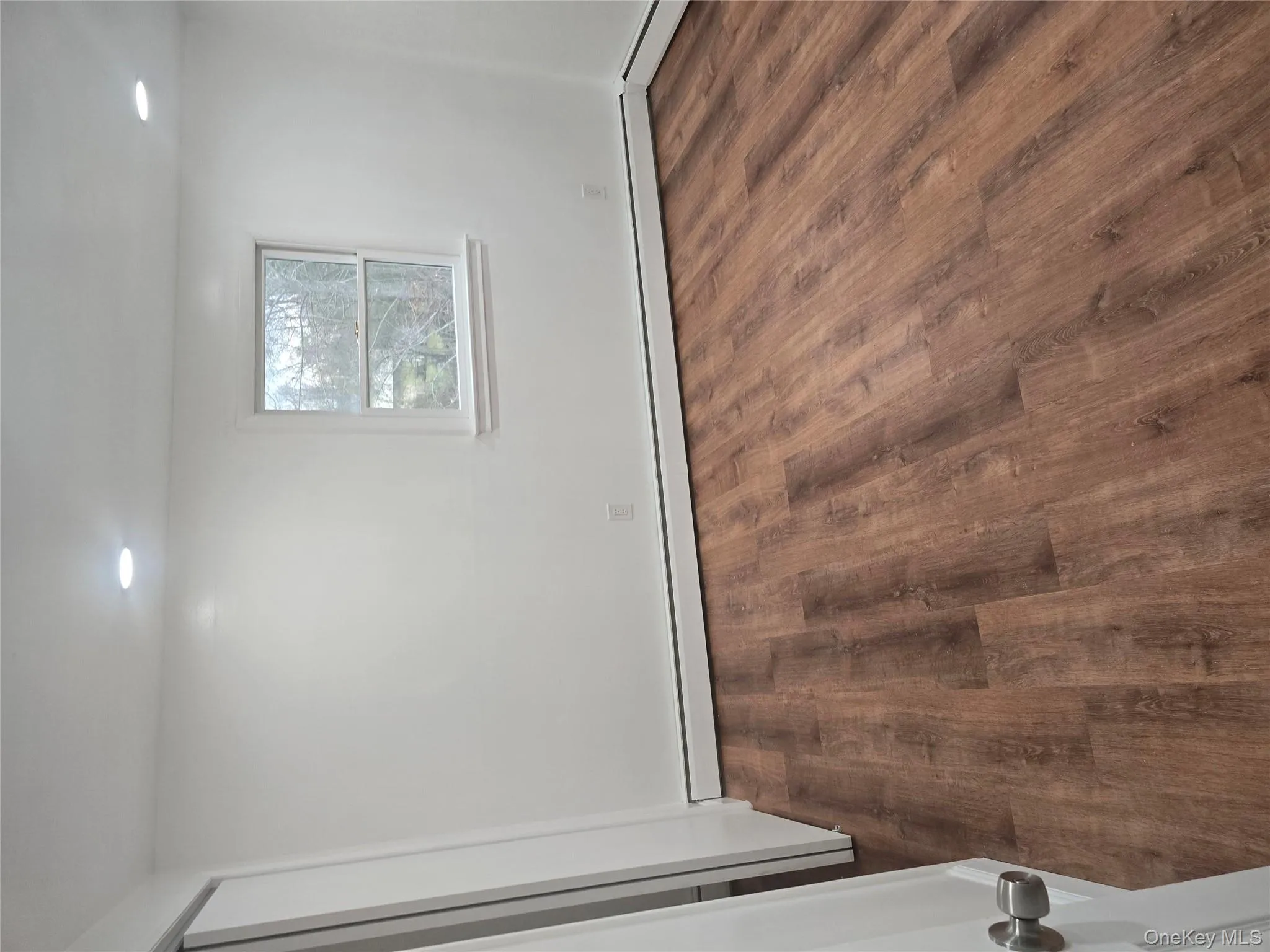 Empty room with dark wood-type flooring, a baseboard heating unit, and recessed lighting Empty room with dark wood-type flooring, a baseboard heating unit, and recessed lighting