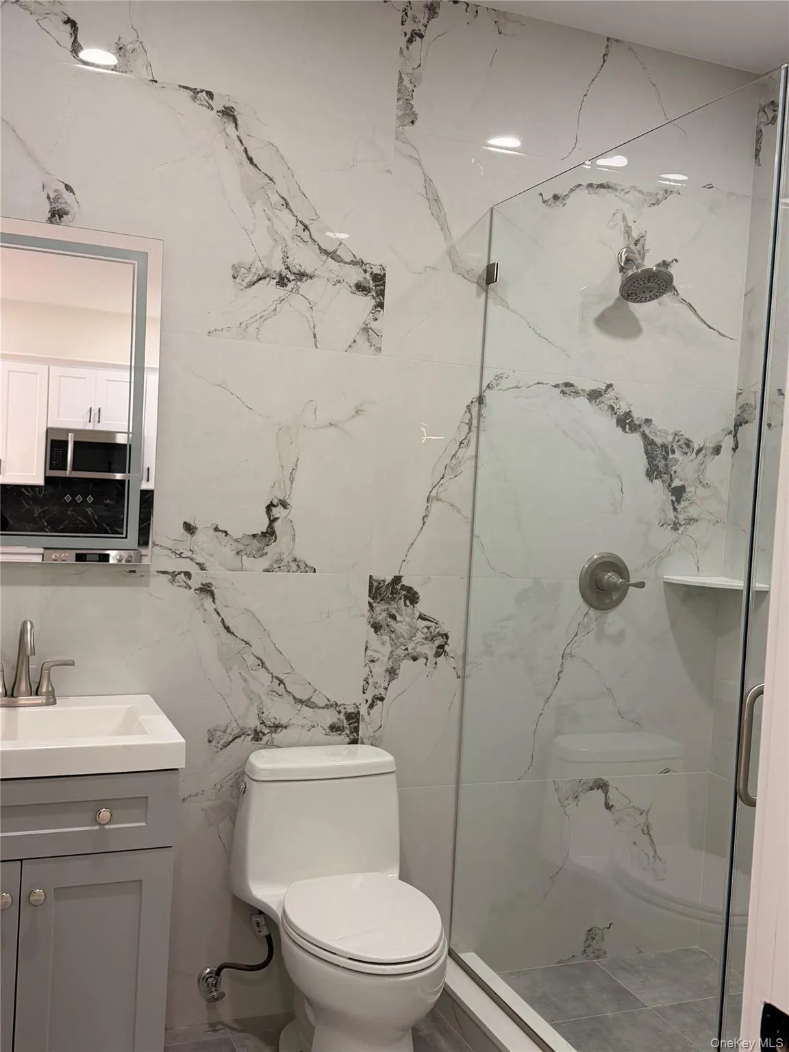 Bathroom with vanity and a marble finish shower Bathroom with vanity and a marble finish shower