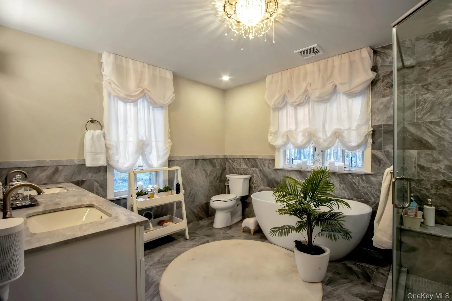 Full bathroom featuring vanity, a healthy amount of sunlight, tile walls, and toilet Full bathroom featuring vanity, a healthy amount of sunlight, tile walls, and toilet