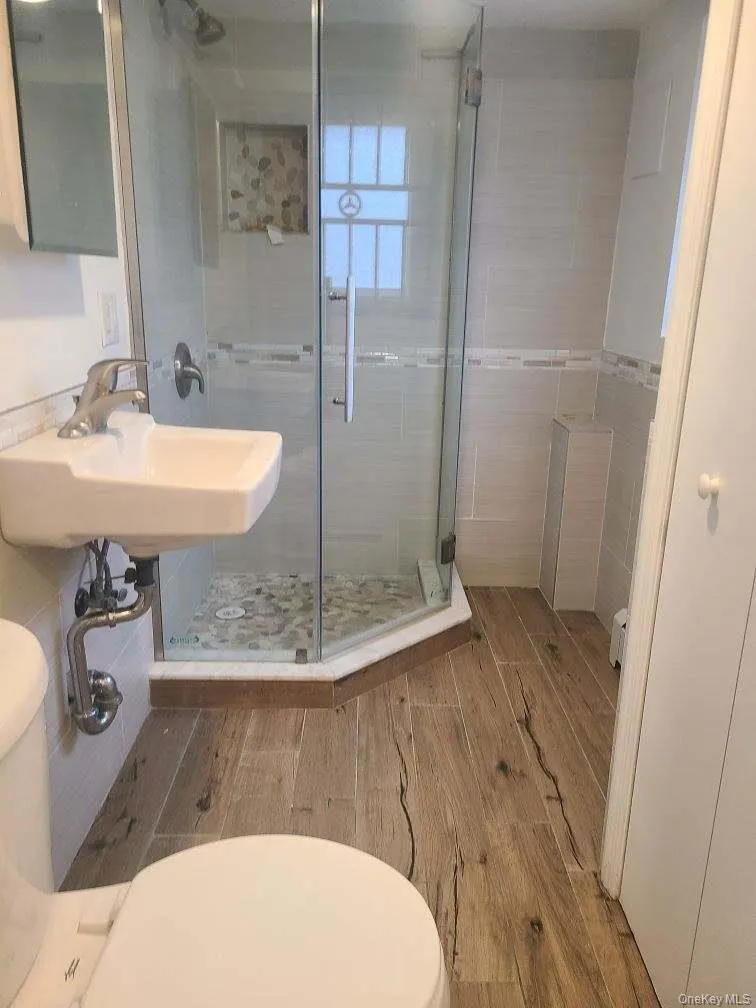 Full bath featuring a stall shower and wood finish floors Full bath featuring a stall shower and wood finish floors