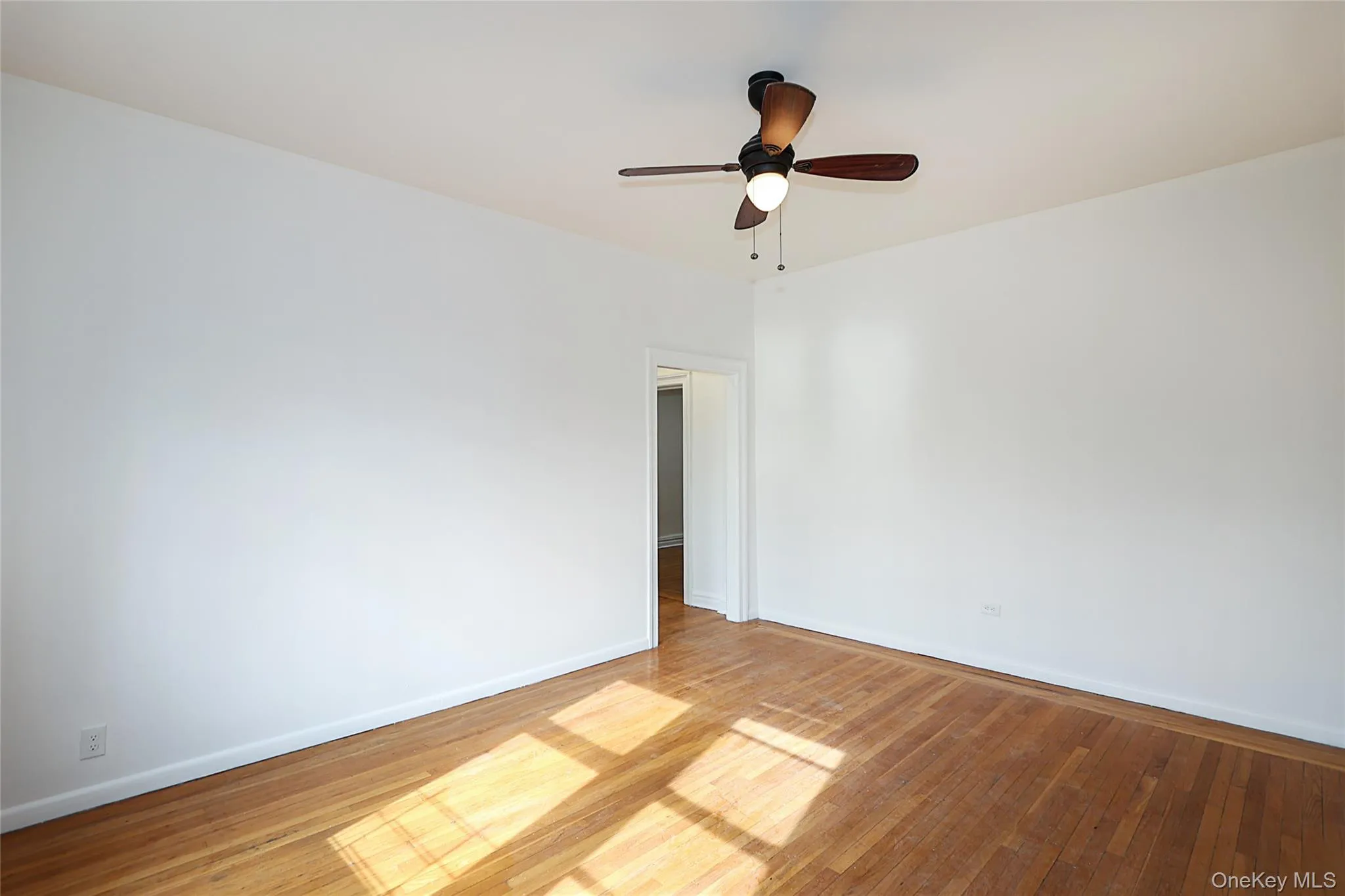 Empty room featuring light wood finished floors and ceiling fan Empty room featuring light wood finished floors and ceiling fan