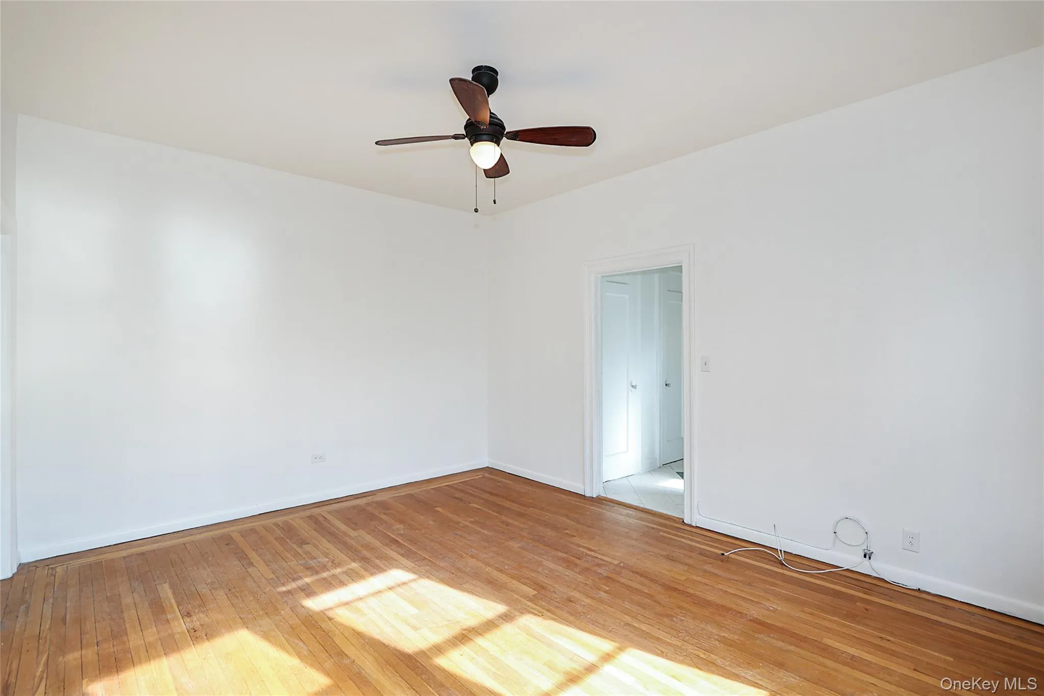 Spare room featuring light wood finished floors and ceiling fan Spare room featuring light wood finished floors and ceiling fan