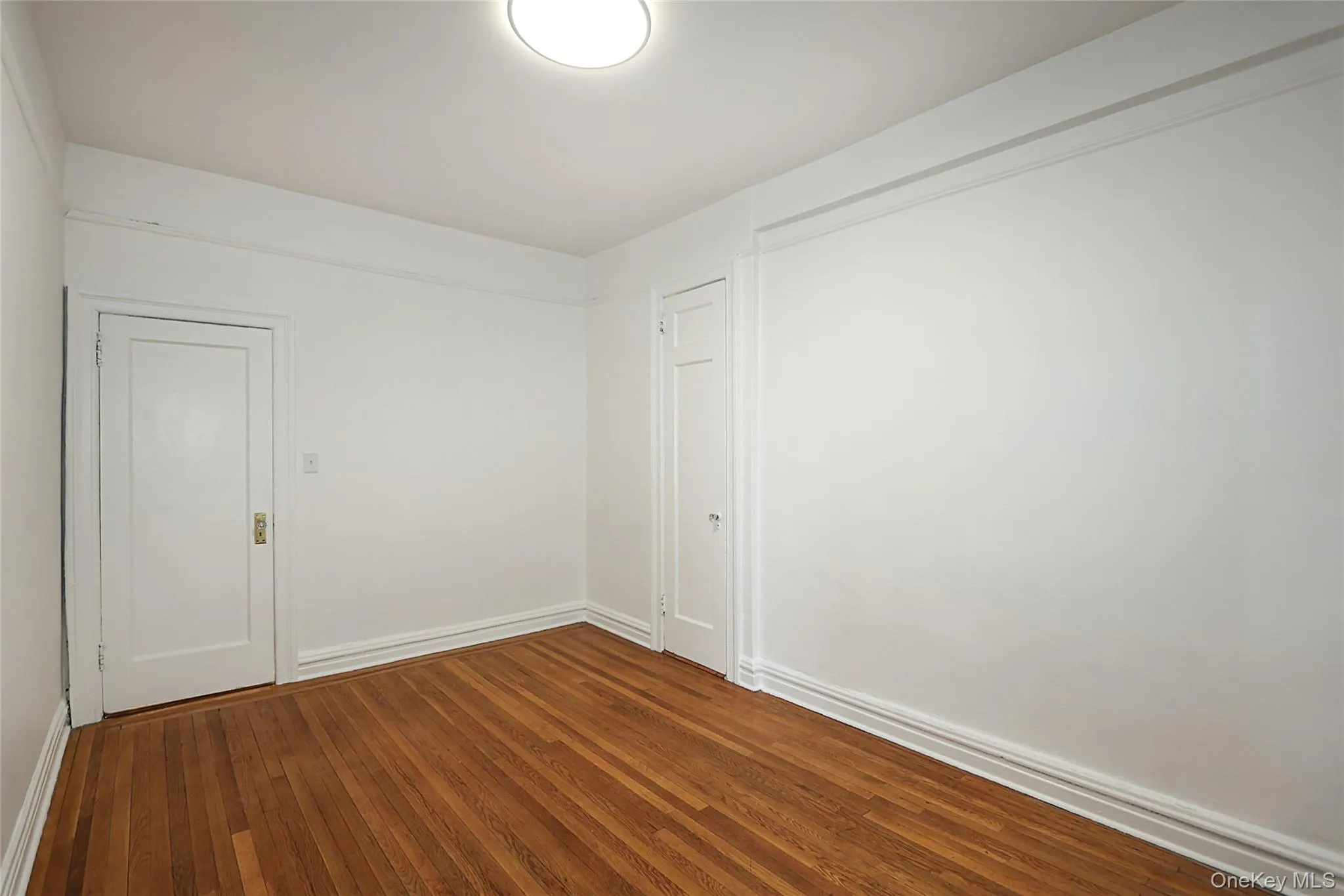 Empty room with hardwood / wood-style floors and baseboards Empty room with hardwood / wood-style floors and baseboards