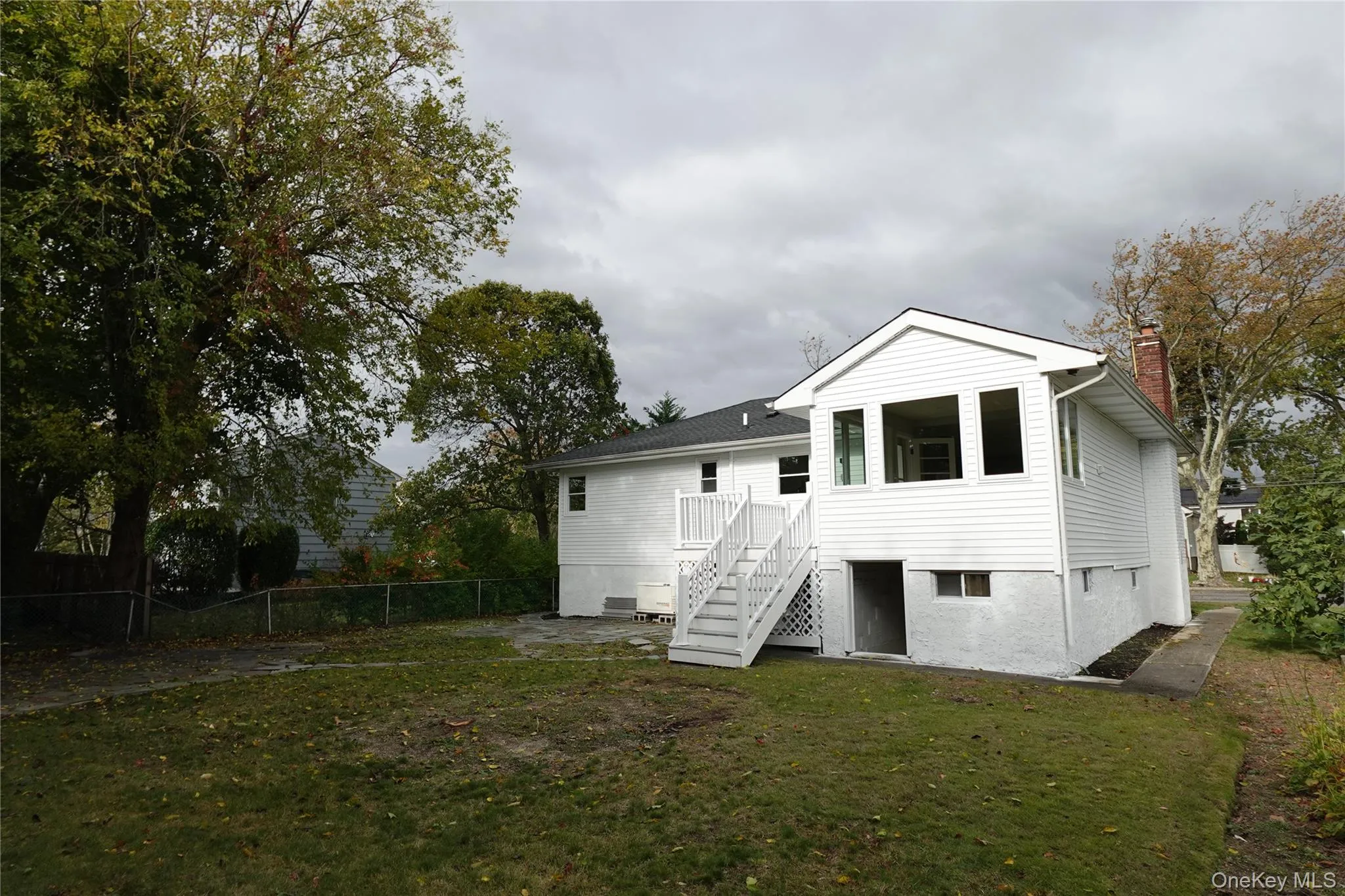 Back of house featuring stairs and a chimney Back of house featuring stairs and a chimney