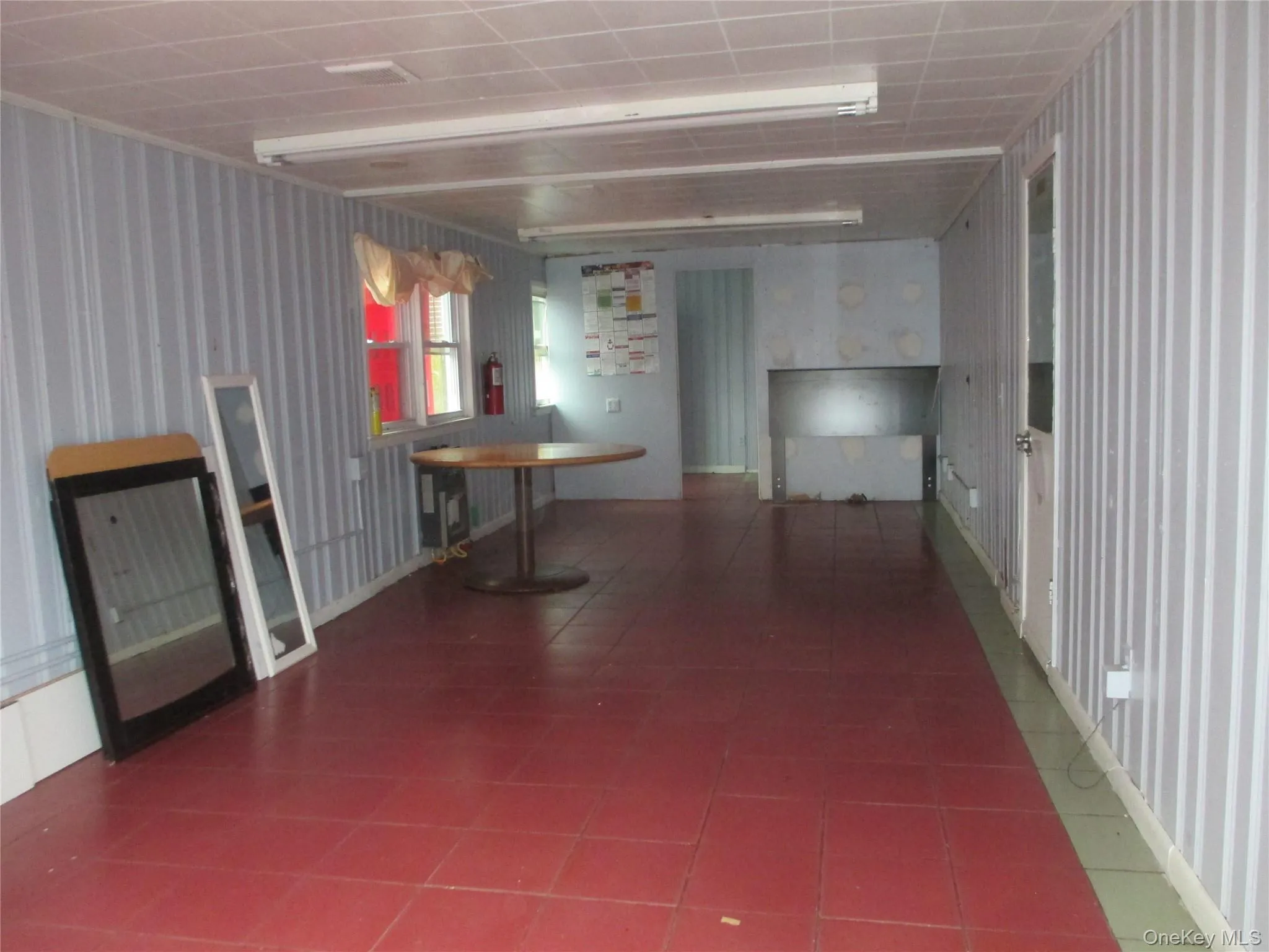 Basement featuring wallpapered walls and dark tile patterned floors Basement featuring wallpapered walls and dark tile patterned floors