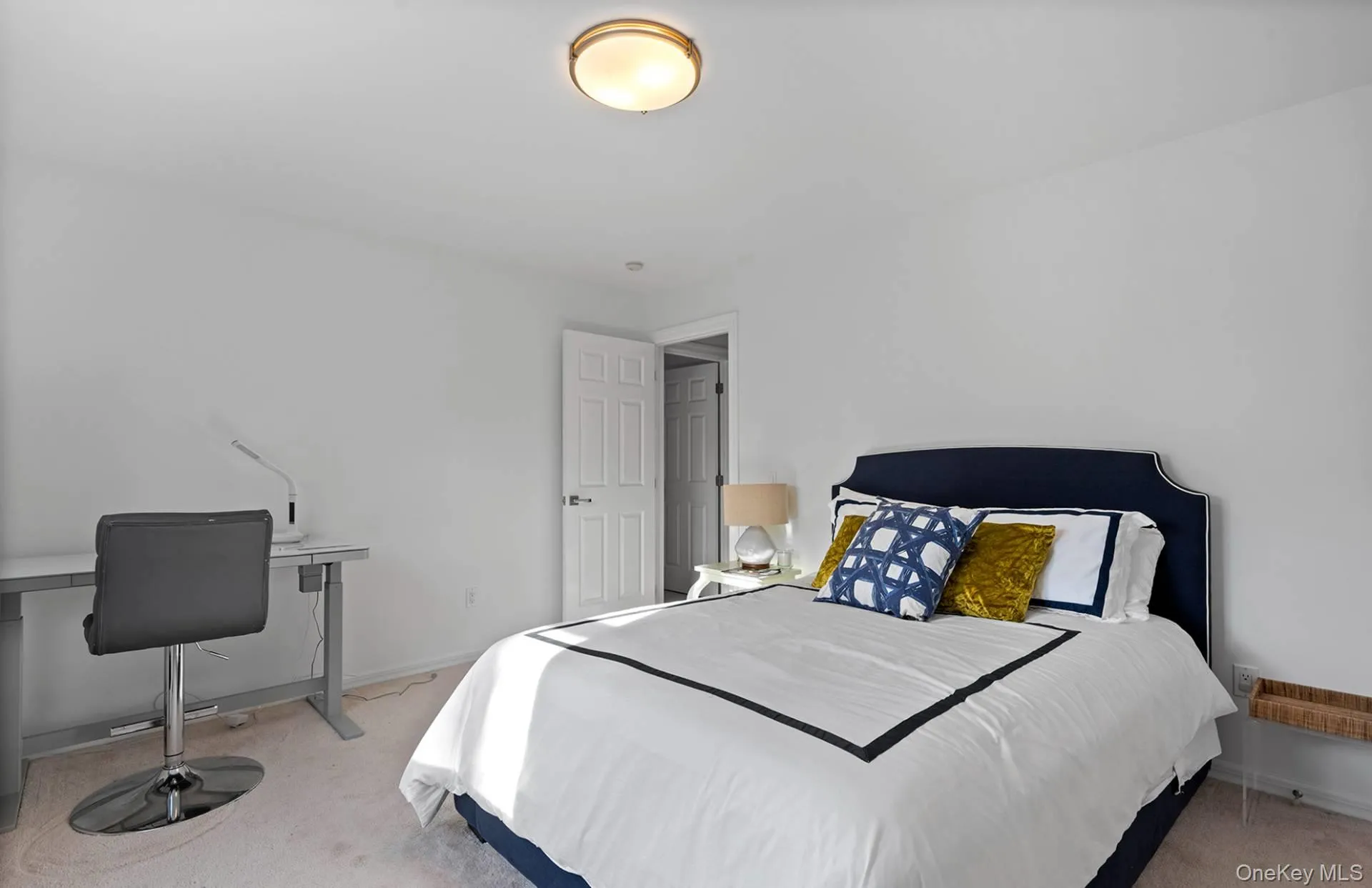 Bedroom with light carpet and an office area Bedroom with light carpet and an office area