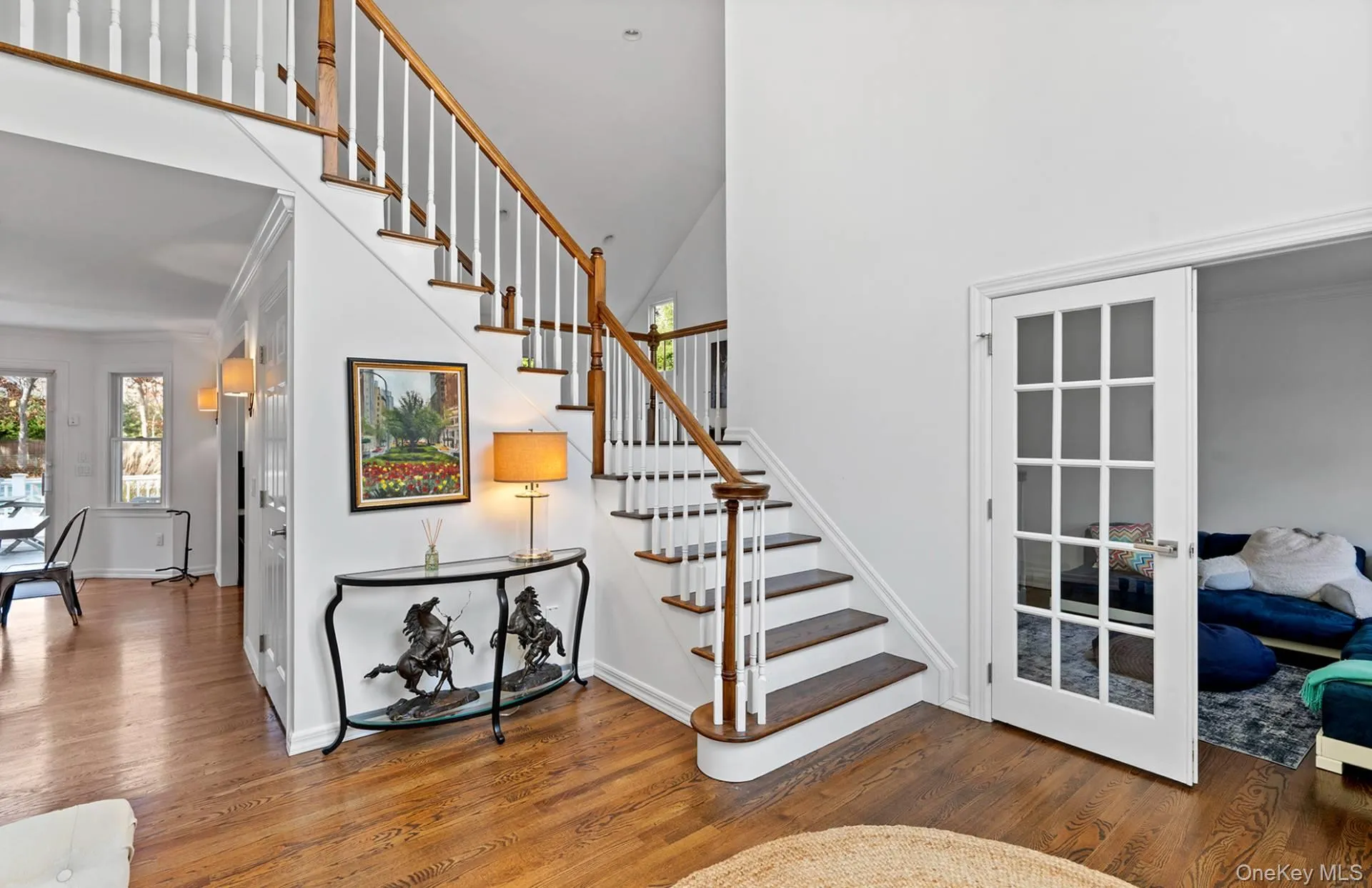 Stairs with wood finished floors, crown molding, and a high ceiling Stairs with wood finished floors, crown molding, and a high ceiling