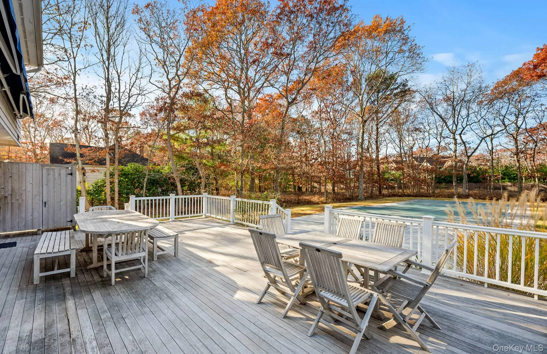 Wooden deck with outdoor dining area and a pool Wooden deck with outdoor dining area and a pool