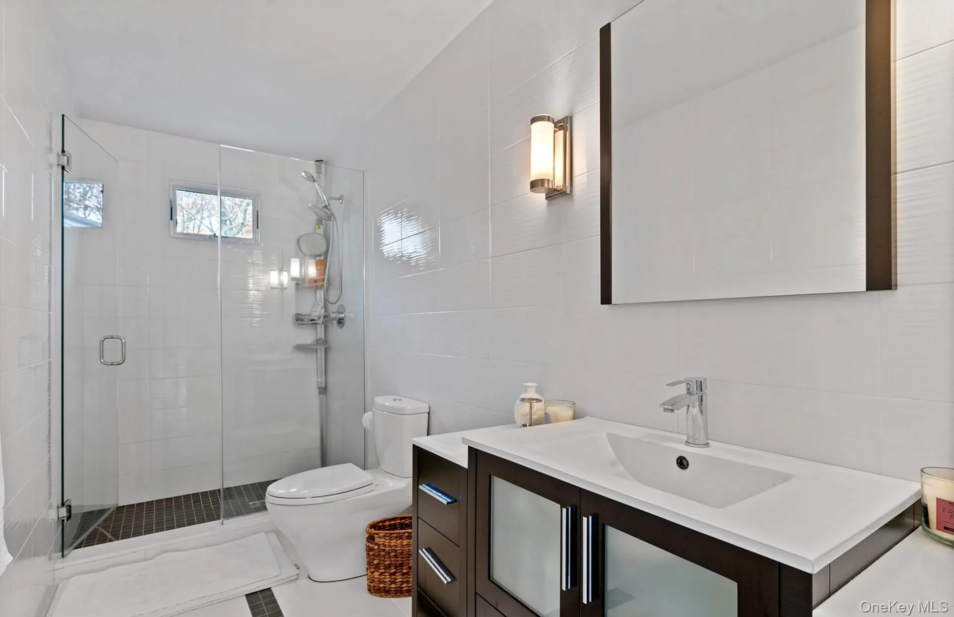 Bathroom with vanity, a stall shower, and tile walls Bathroom with vanity, a stall shower, and tile walls