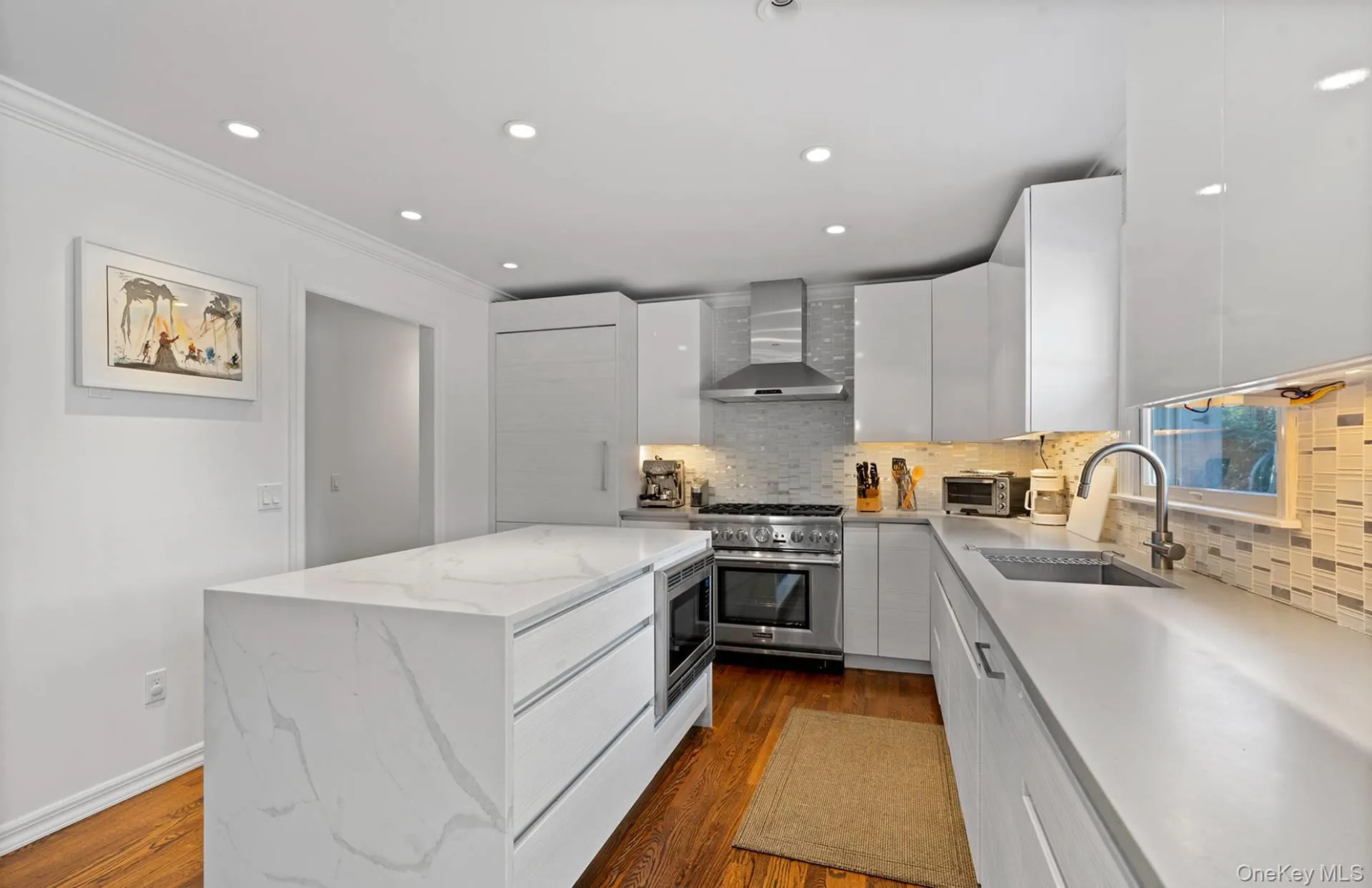 Kitchen featuring modern cabinets, light stone counters, a kitchen island, stainless steel appliances, and recessed lighting Kitchen featuring modern cabinets, light stone counters, a kitchen island, stainless steel appliances, and recessed lighting
