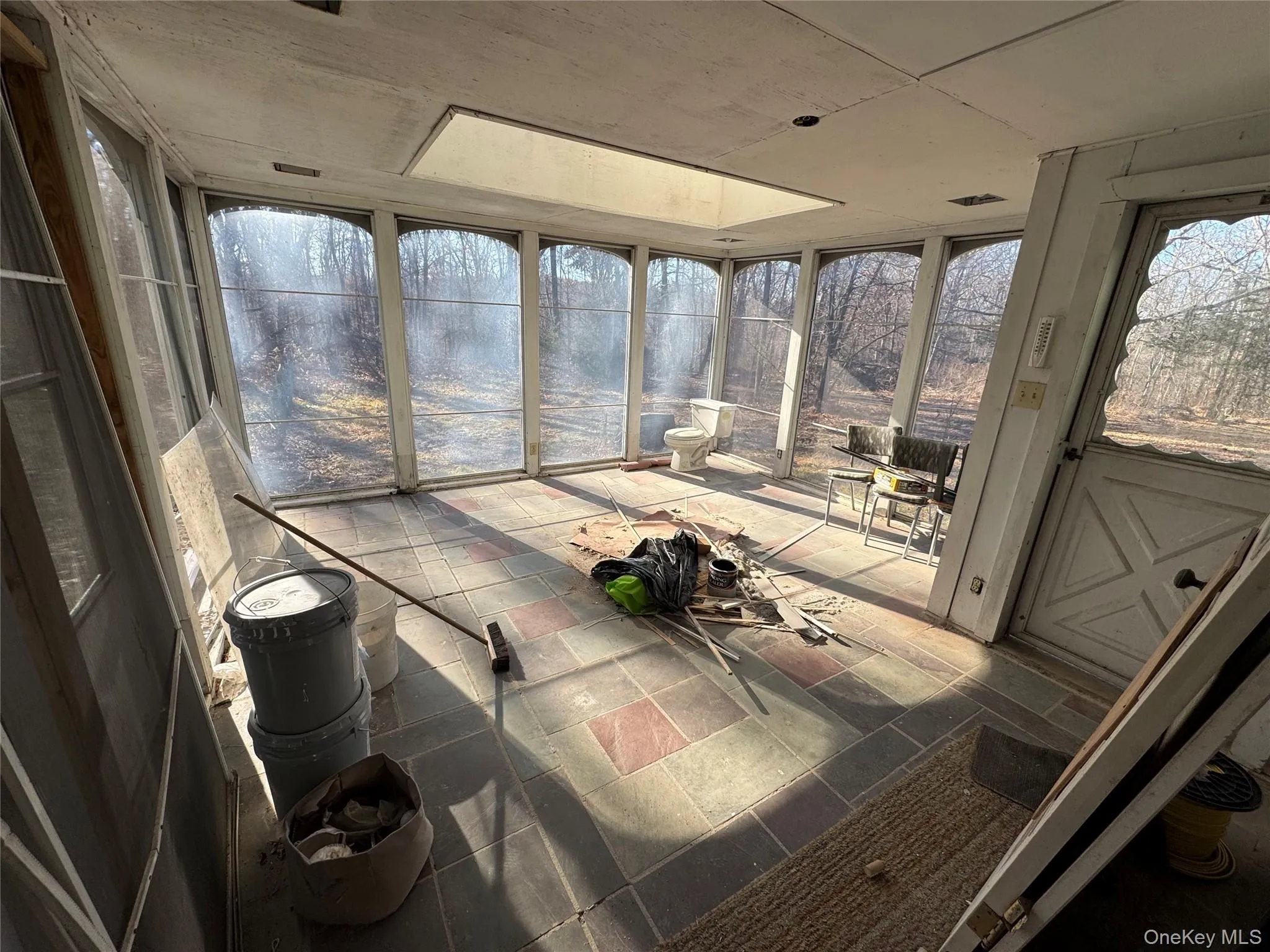 Sunroom / solarium featuring expansive windows and stone tile floors Sunroom / solarium featuring expansive windows and stone tile floors