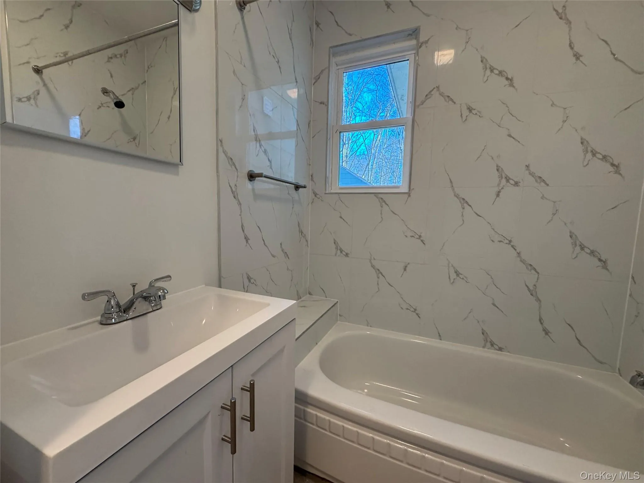 Full bath featuring vanity and a combined bath / shower with marble appearance Full bath featuring vanity and a combined bath / shower with marble appearance