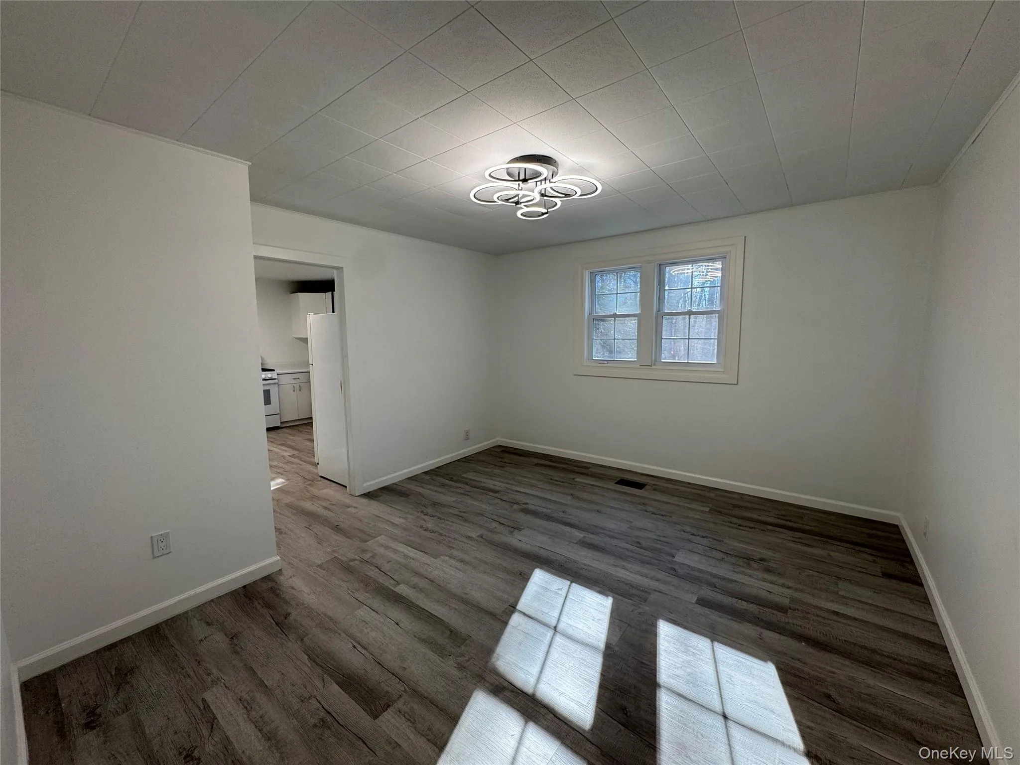 Empty room featuring dark wood-style flooring and baseboards Empty room featuring dark wood-style flooring and baseboards