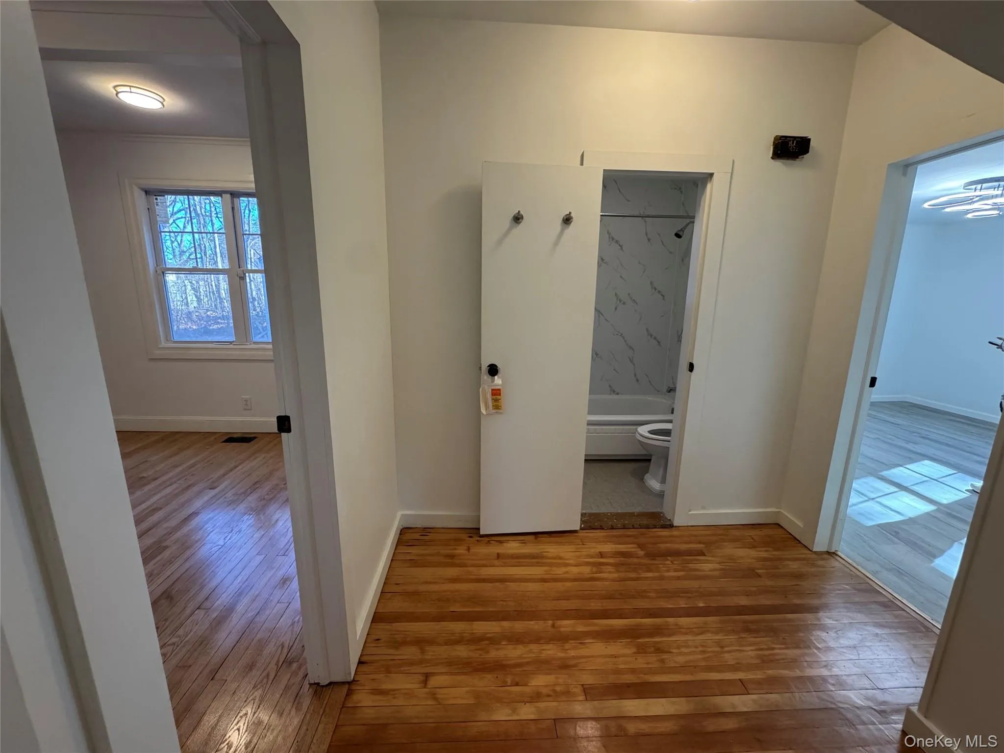 Hallway featuring light wood finished floors and baseboards Hallway featuring light wood finished floors and baseboards