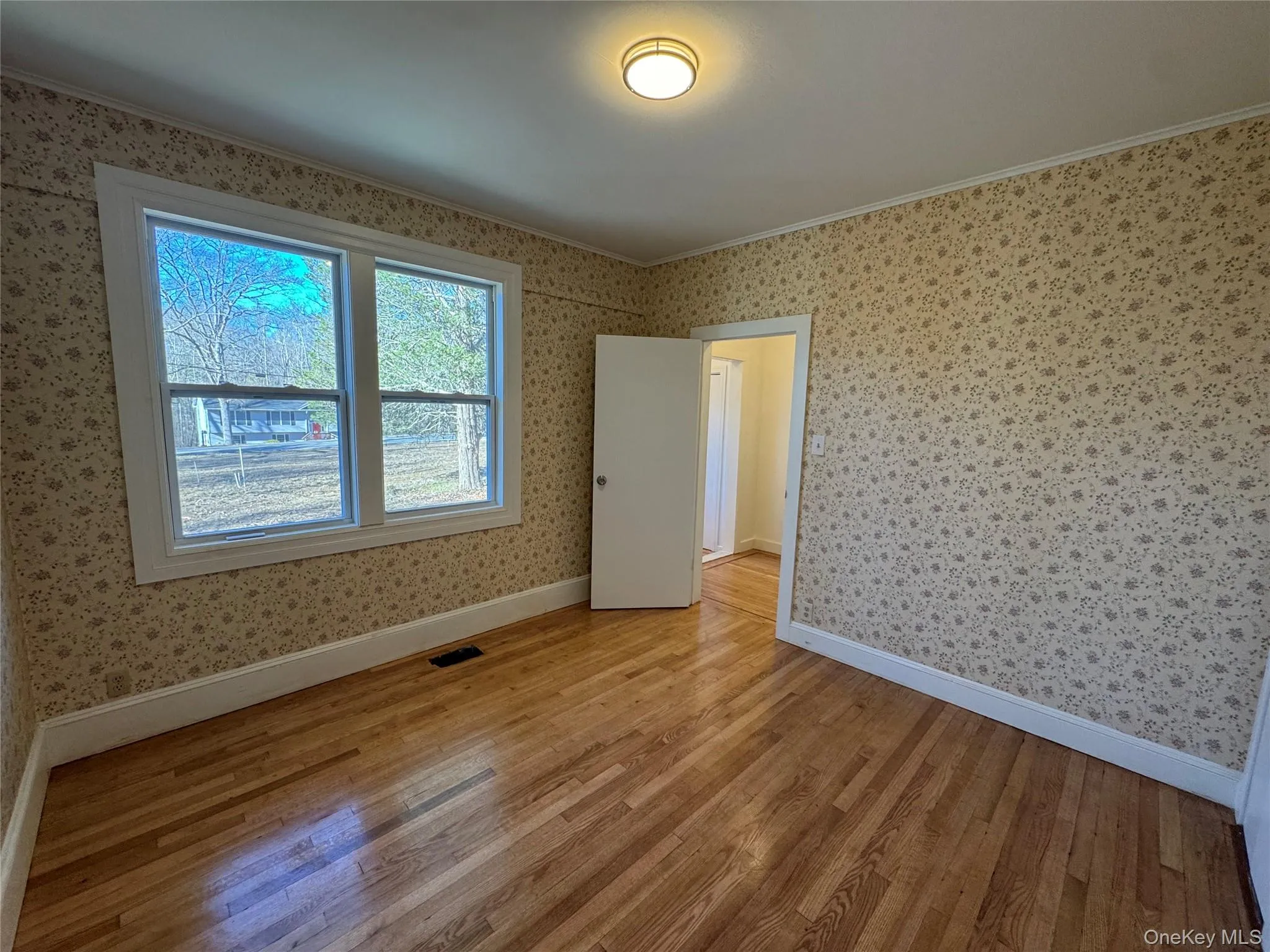 Empty room featuring hardwood / wood-style flooring and crown molding Empty room featuring hardwood / wood-style flooring and crown molding