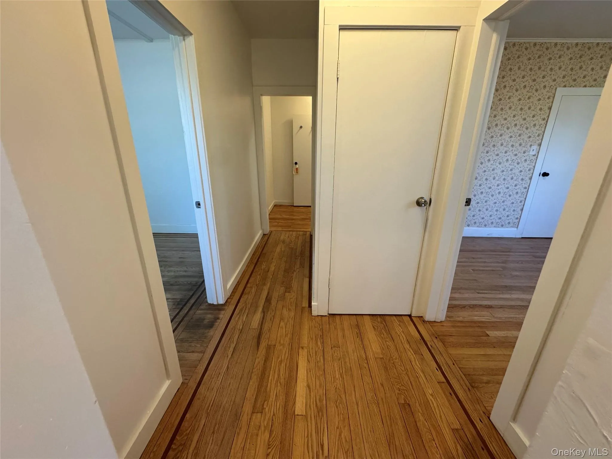 Hall featuring light wood-style flooring and baseboards Hall featuring light wood-style flooring and baseboards