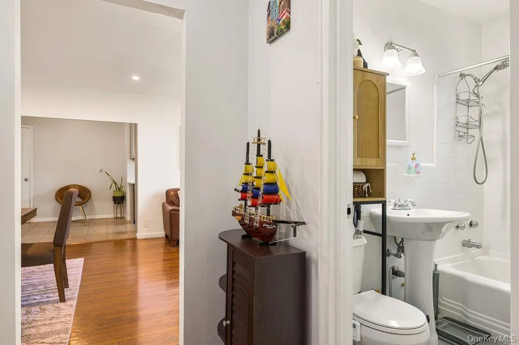 Bathroom with shower / washtub combination, wood finished floors, and recessed lighting Bathroom with shower / washtub combination, wood finished floors, and recessed lighting
