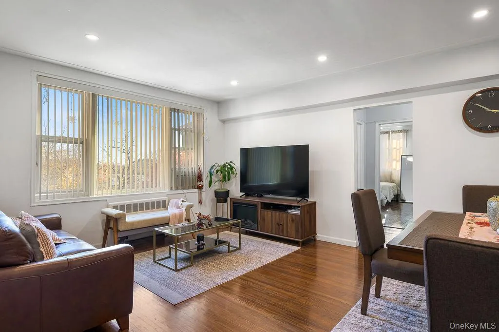 Living area with wood finished floors, plenty of natural light, and recessed lighting Living area with wood finished floors, plenty of natural light, and recessed lighting