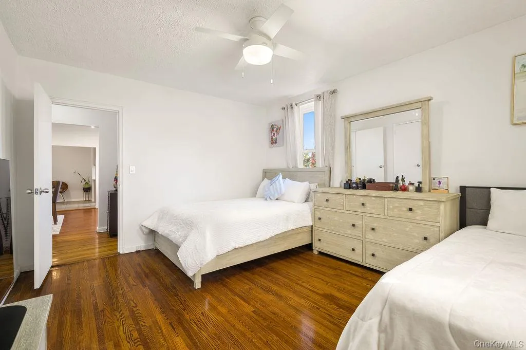 Bedroom featuring dark wood-style flooring, ceiling fan, and a textured ceiling Bedroom featuring dark wood-style flooring, ceiling fan, and a textured ceiling