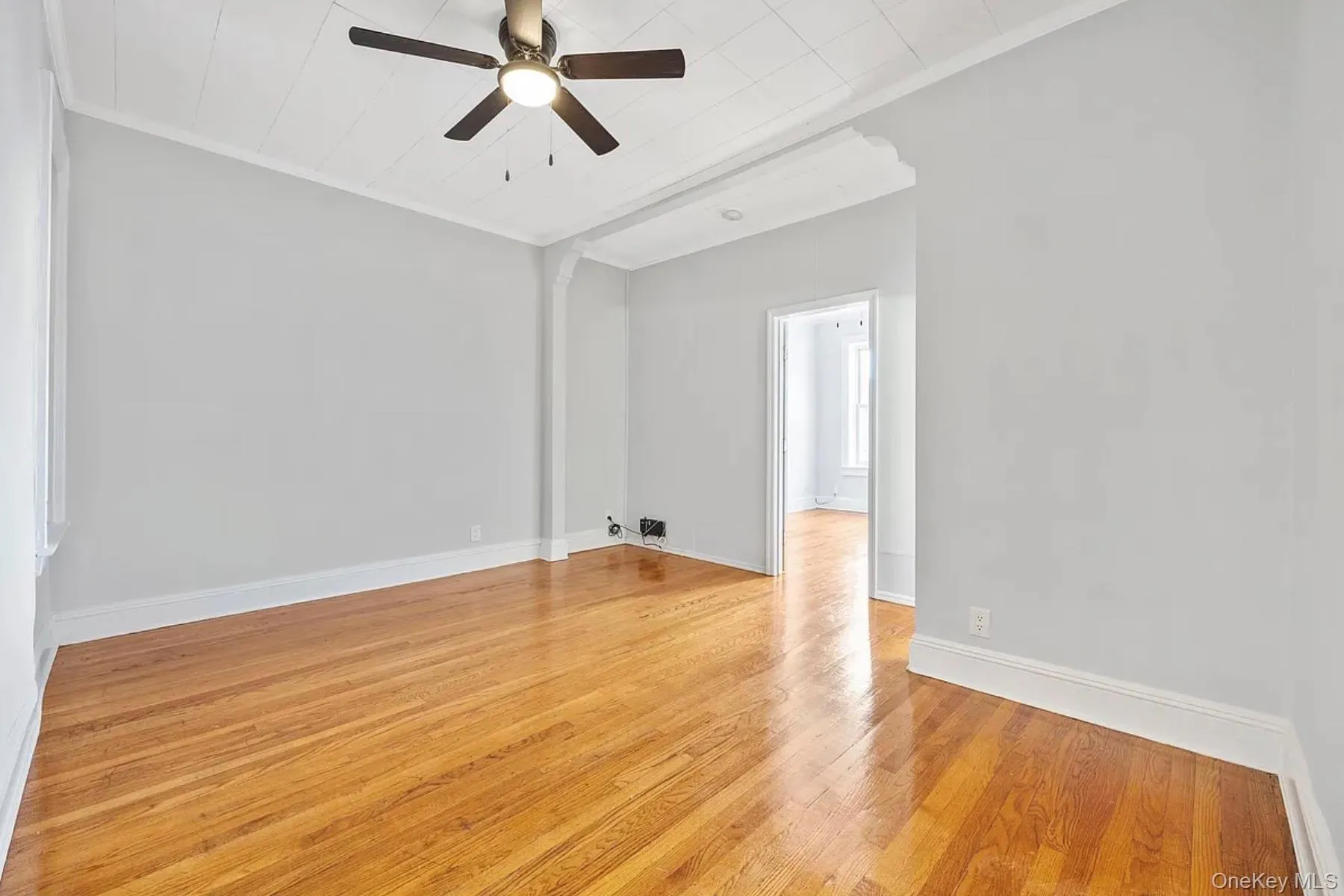 Unfurnished room featuring crown molding, light wood-style flooring, and a ceiling fan Unfurnished room featuring crown molding, light wood-style flooring, and a ceiling fan
