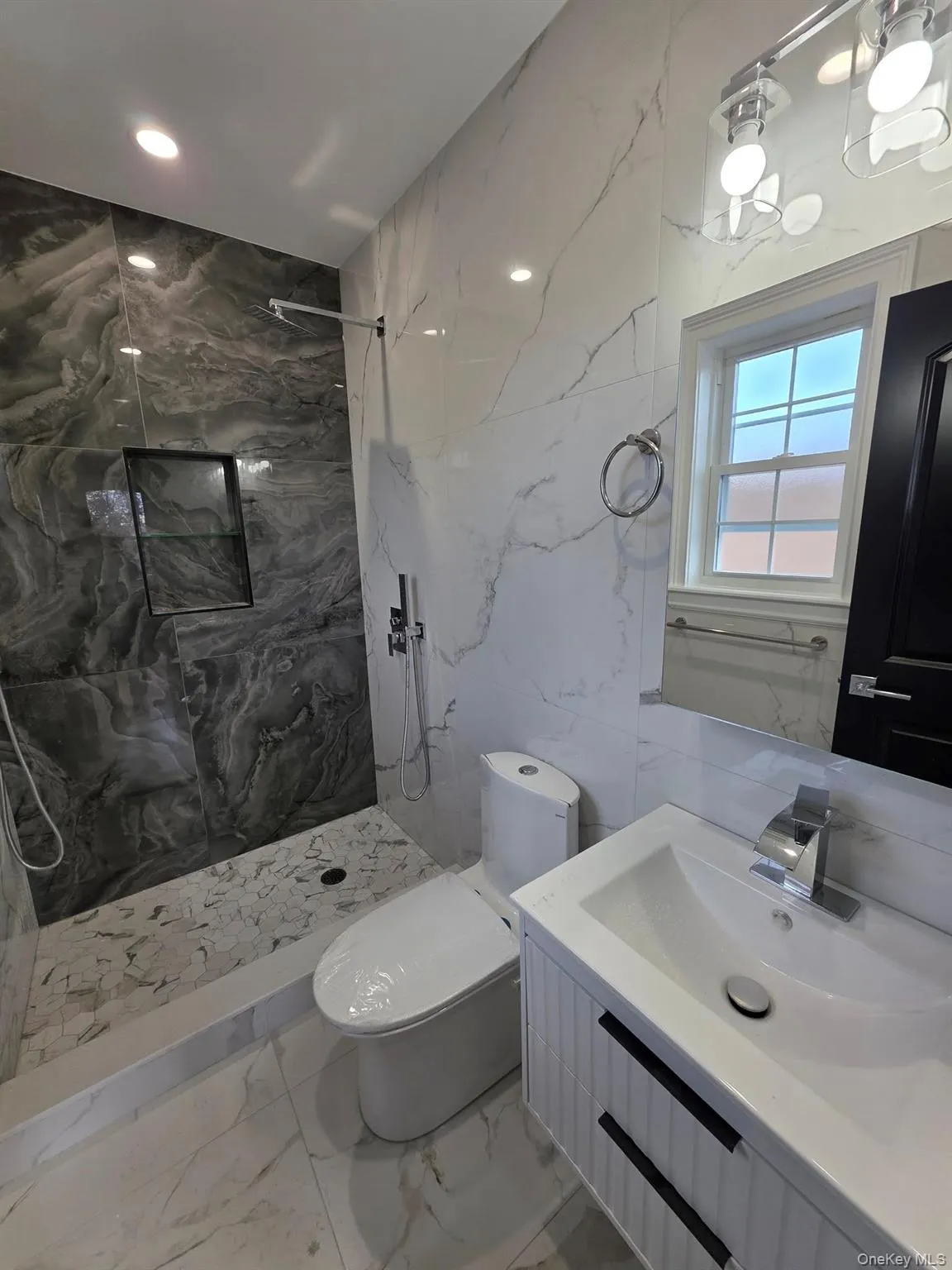Bathroom featuring a marble finish shower, vanity, light marble finish floors, stone wall, and recessed lighting Bathroom featuring a marble finish shower, vanity, light marble finish floors, stone wall, and recessed lighting