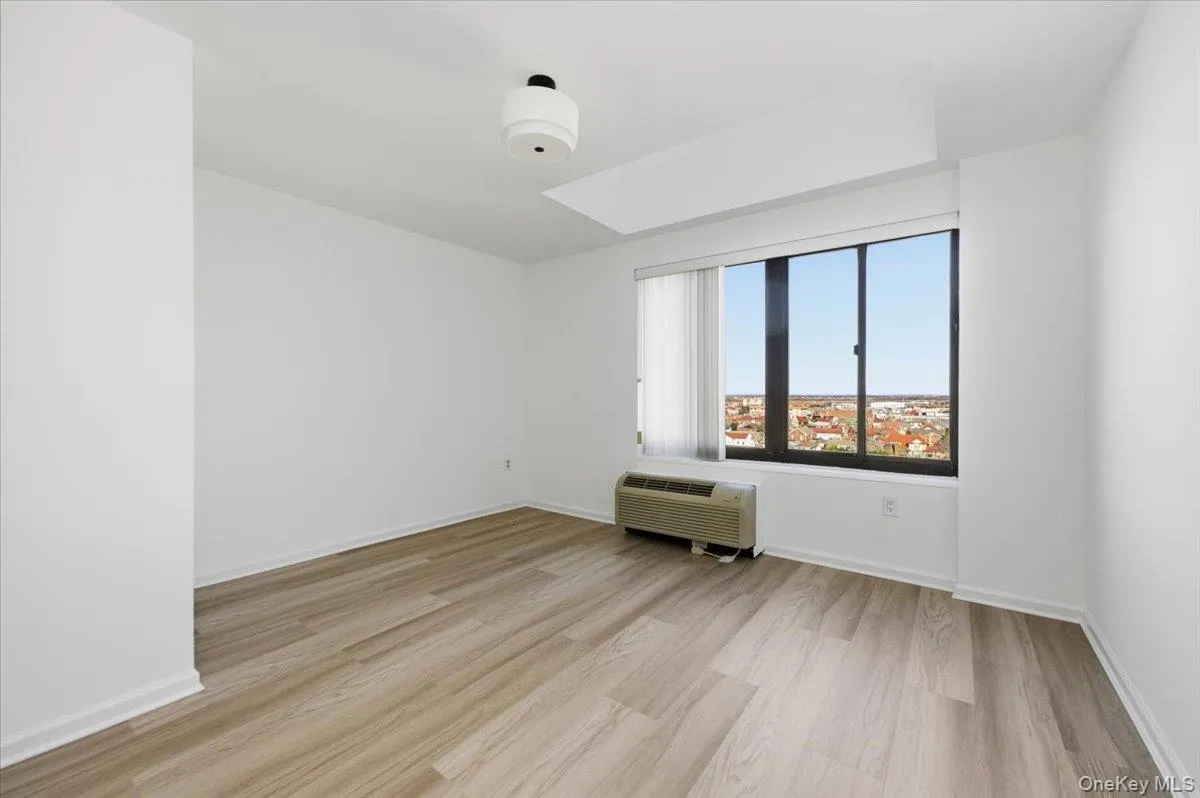 Unfurnished room with light wood-type flooring and a wall mounted air conditioner Unfurnished room with light wood-type flooring and a wall mounted air conditioner