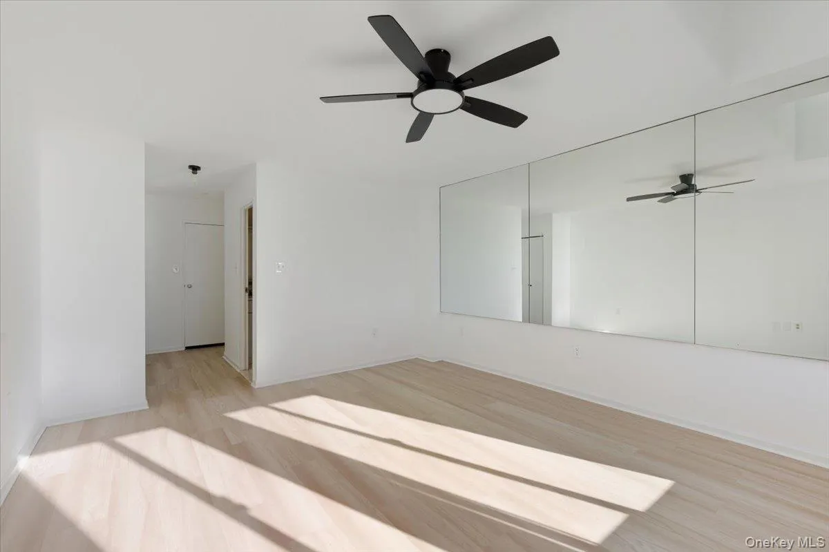 Spare room with light wood finished floors and a ceiling fan Spare room with light wood finished floors and a ceiling fan