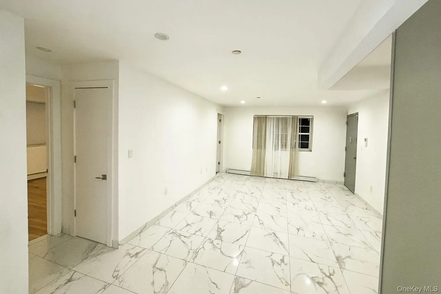 Spare room featuring light marble finish floors, baseboard heating, and recessed lighting Spare room featuring light marble finish floors, baseboard heating, and recessed lighting