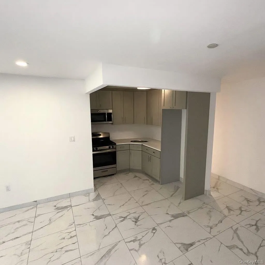 Kitchen with light countertops, appliances with stainless steel finishes, light marble finish flooring, and recessed lighting Kitchen with light countertops, appliances with stainless steel finishes, light marble finish flooring, and recessed lighting