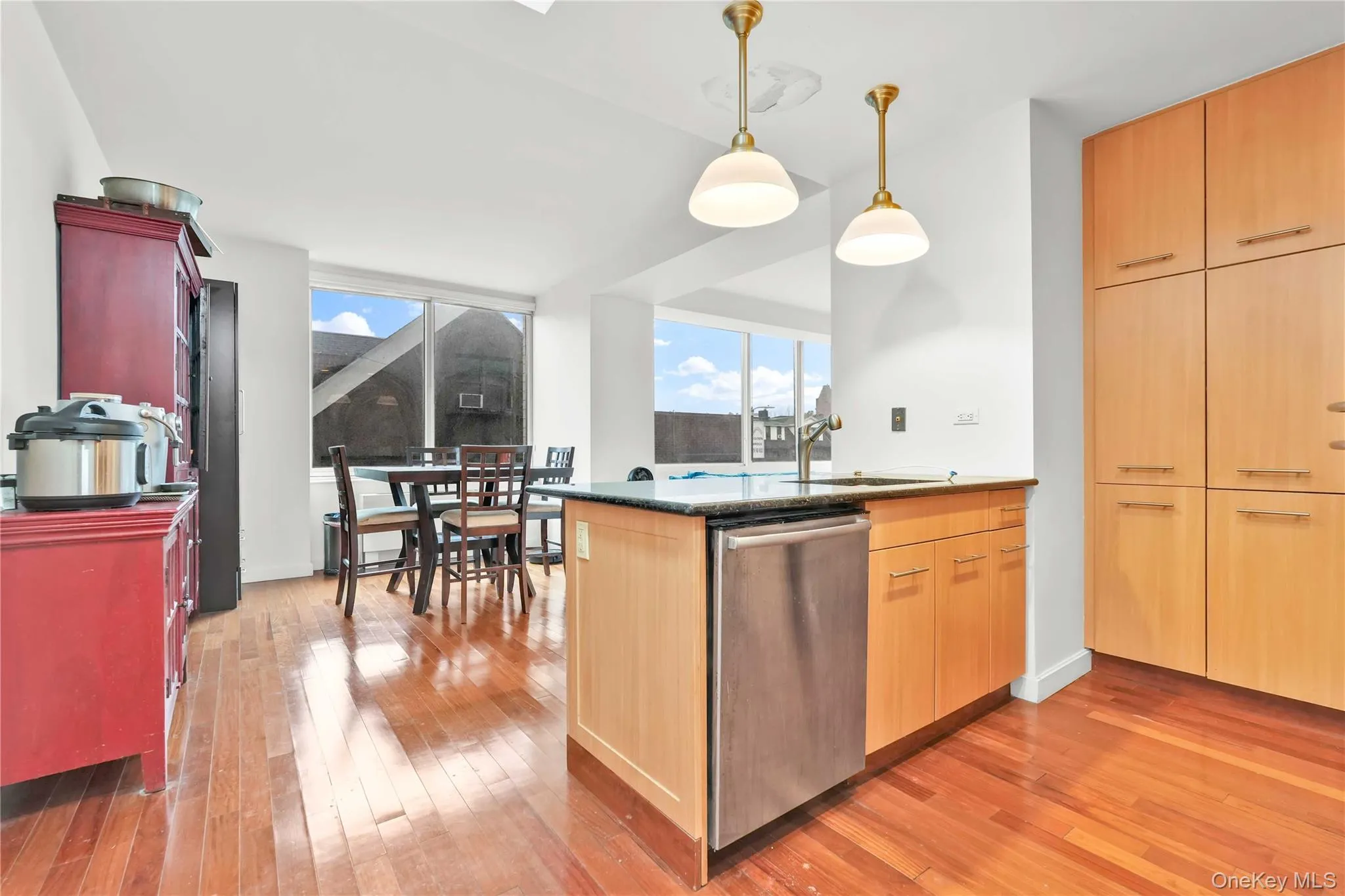 Kitchen with dishwasher, a peninsula, dark stone counters, and light wood-style floors Kitchen with dishwasher, a peninsula, dark stone counters, and light wood-style floors