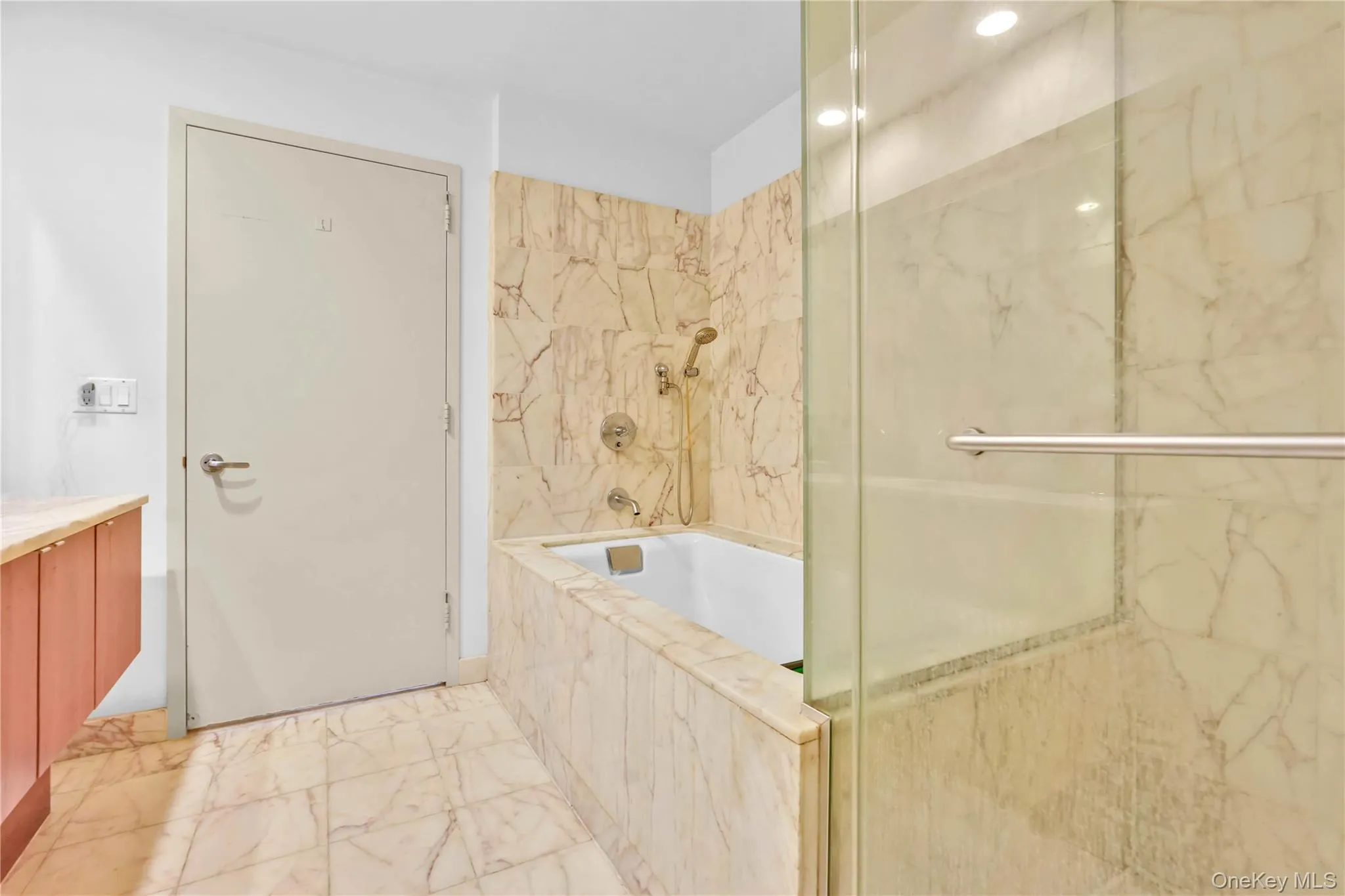 Bathroom featuring light marble finish floors, a marble finish shower, vanity, and tiled tub Bathroom featuring light marble finish floors, a marble finish shower, vanity, and tiled tub