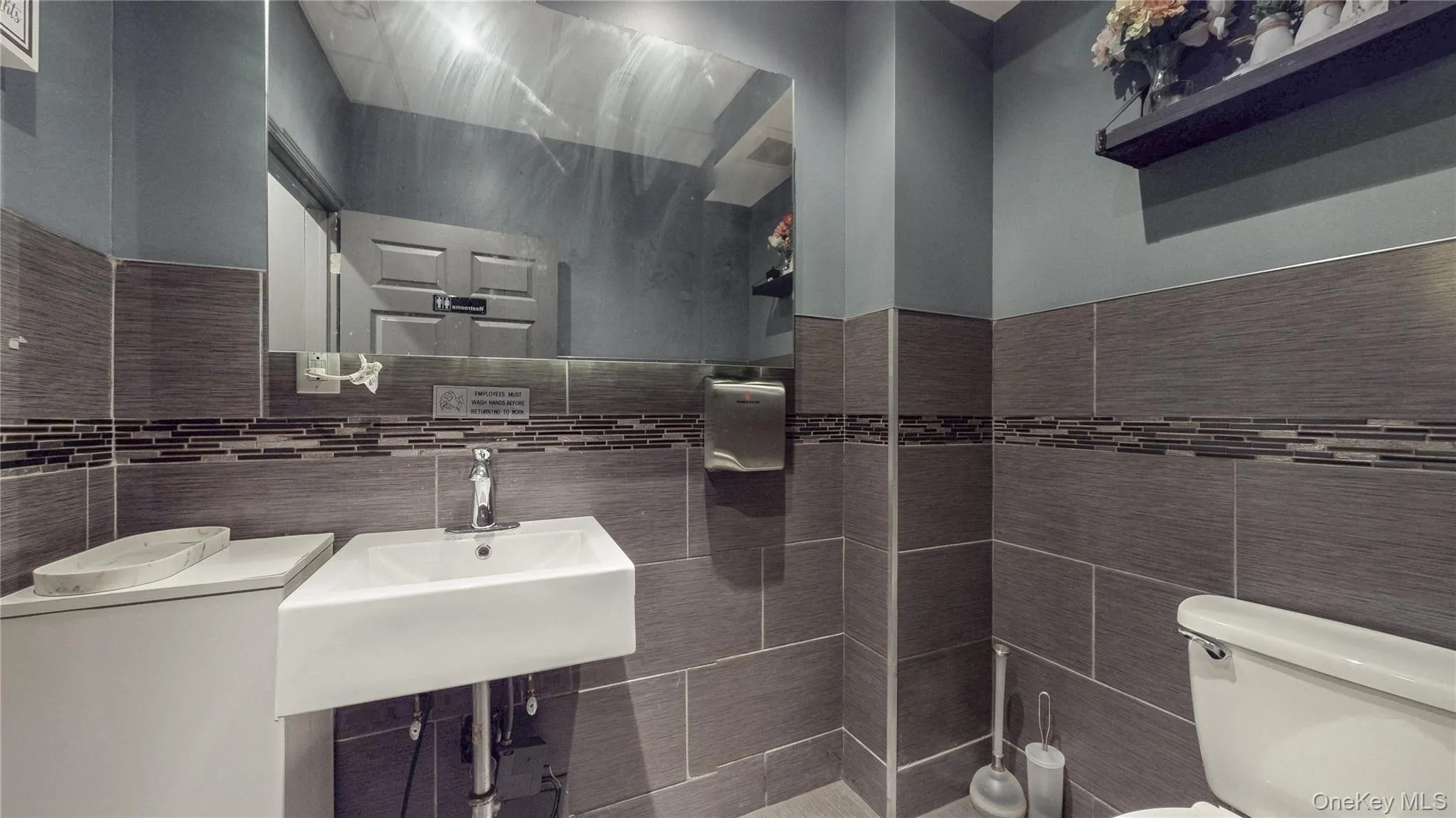 Bathroom featuring toilet and tile walls Bathroom featuring toilet and tile walls