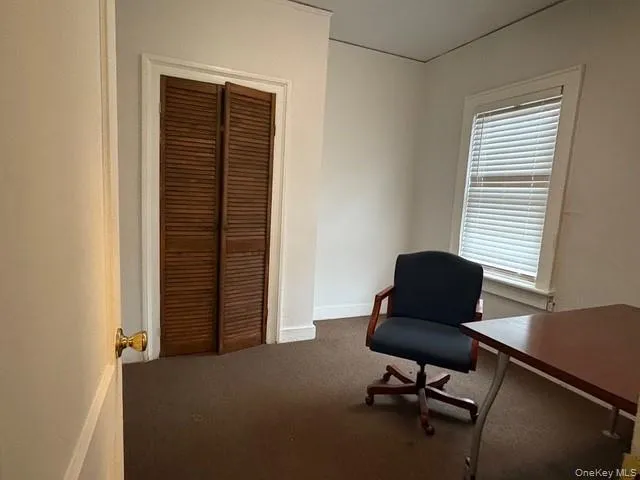 Office area featuring dark carpet and baseboards Office area featuring dark carpet and baseboards