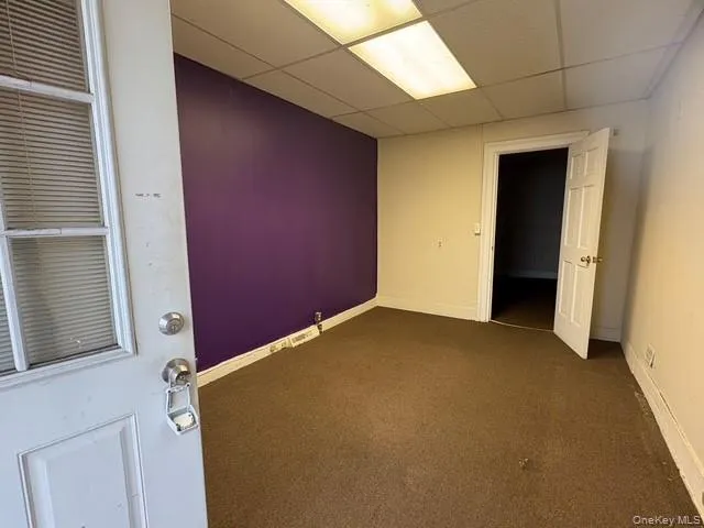 Empty room featuring carpet floors and a paneled ceiling Empty room featuring carpet floors and a paneled ceiling