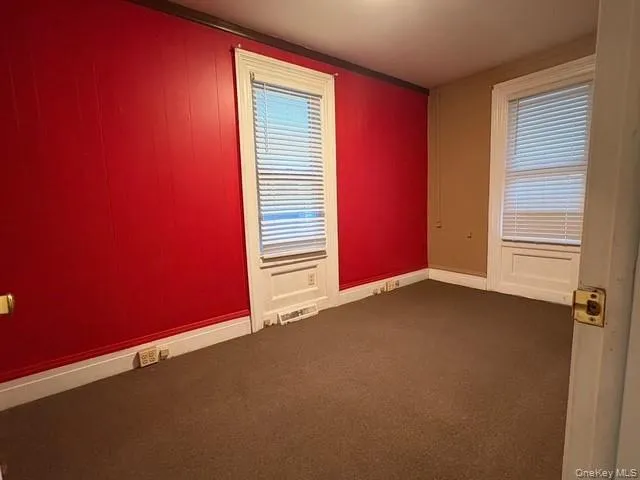 Spare room with baseboards and dark carpet Spare room with baseboards and dark carpet