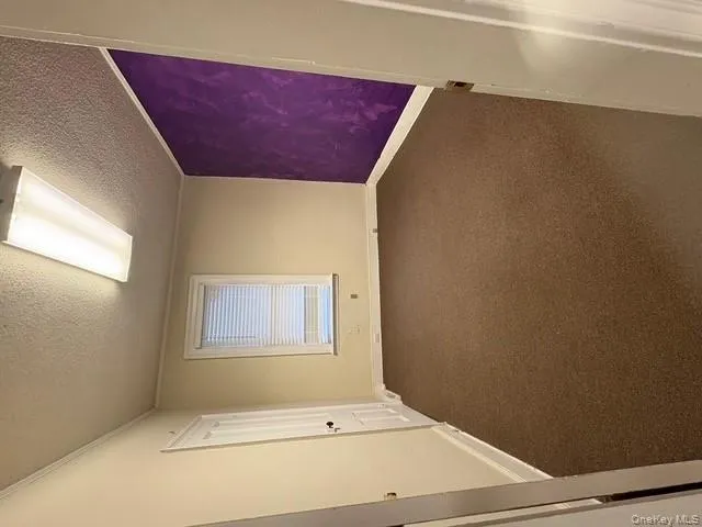 Unfurnished room with dark colored carpet, a textured ceiling, and crown molding Unfurnished room with dark colored carpet, a textured ceiling, and crown molding