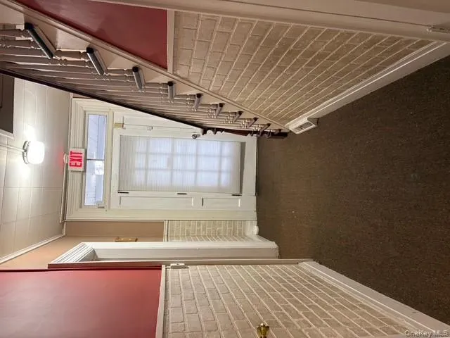 Entryway featuring wainscoting, brick wall, stairs, carpet flooring, and ornamental molding Entryway featuring wainscoting, brick wall, stairs, carpet flooring, and ornamental molding